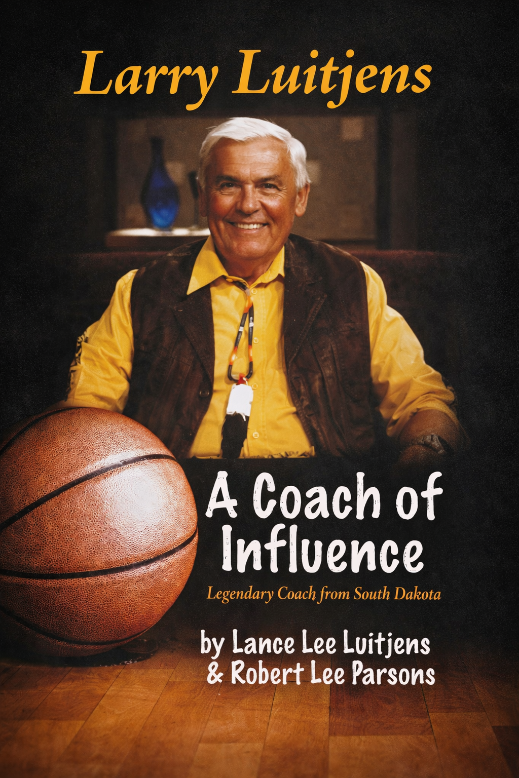 Book cover featuring a smiling older man with white hair, wearing a yellow shirt and brown vest, sitting at a table with a basketball in the foreground. Title reads 'A Coach of Influence' by Lance Lee Luitjens & Robert Lee Parsons.