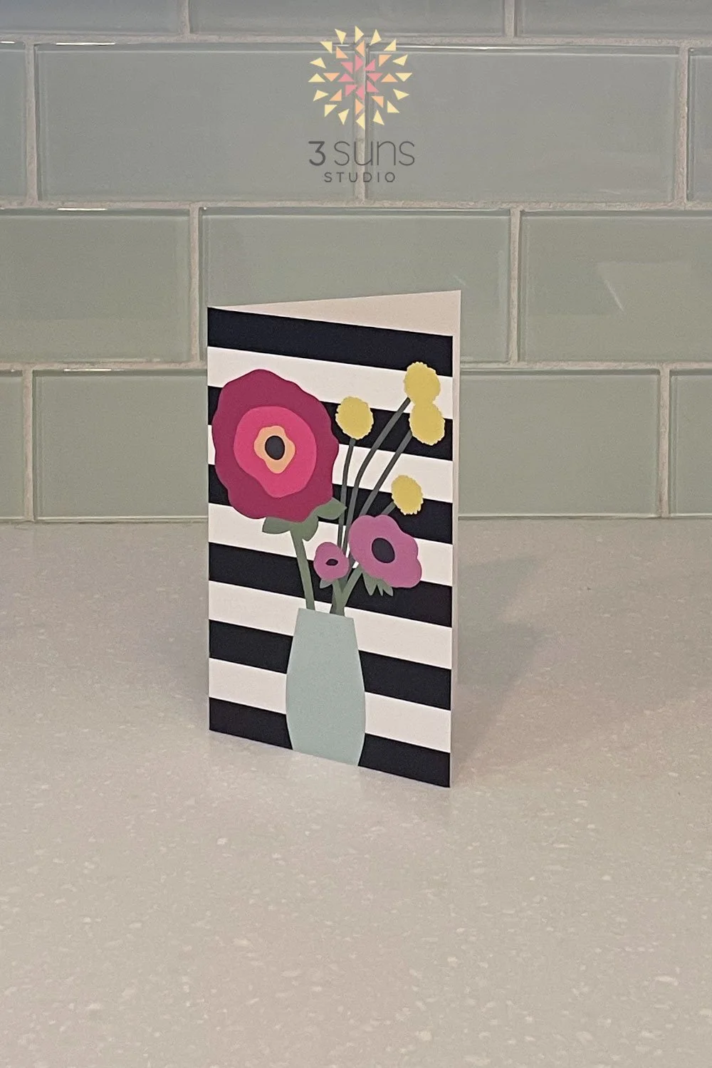Blank notecard featuring a bold modern floral bouquet on a striped background.