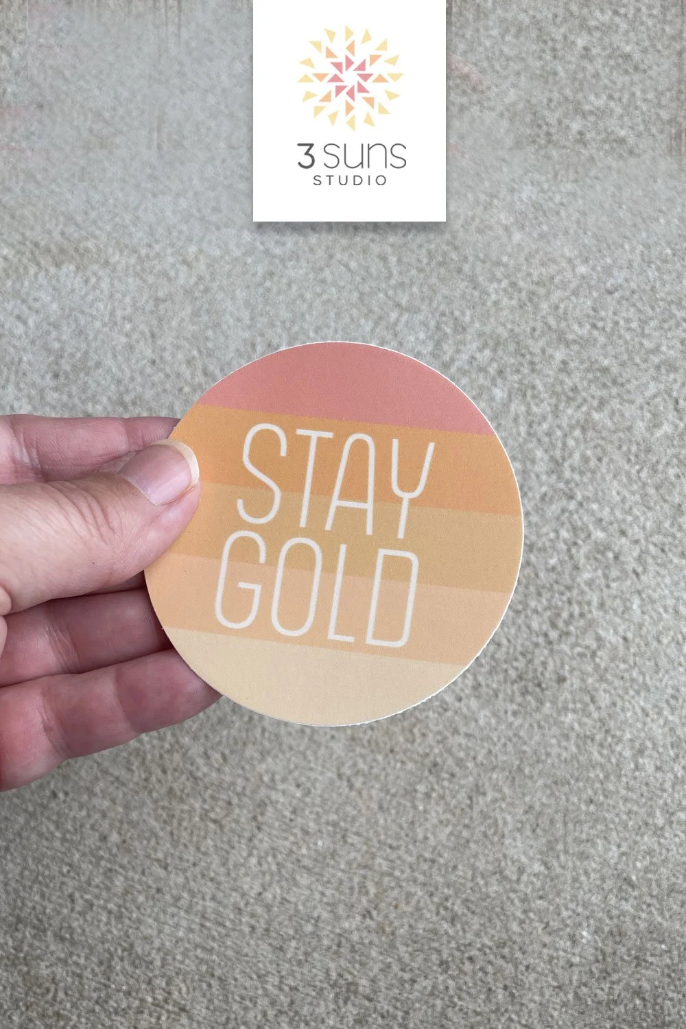A clean and simply designed sticker depicting the inspirational phrase “Stay Gold”. Boho color scheme of orange and gold.