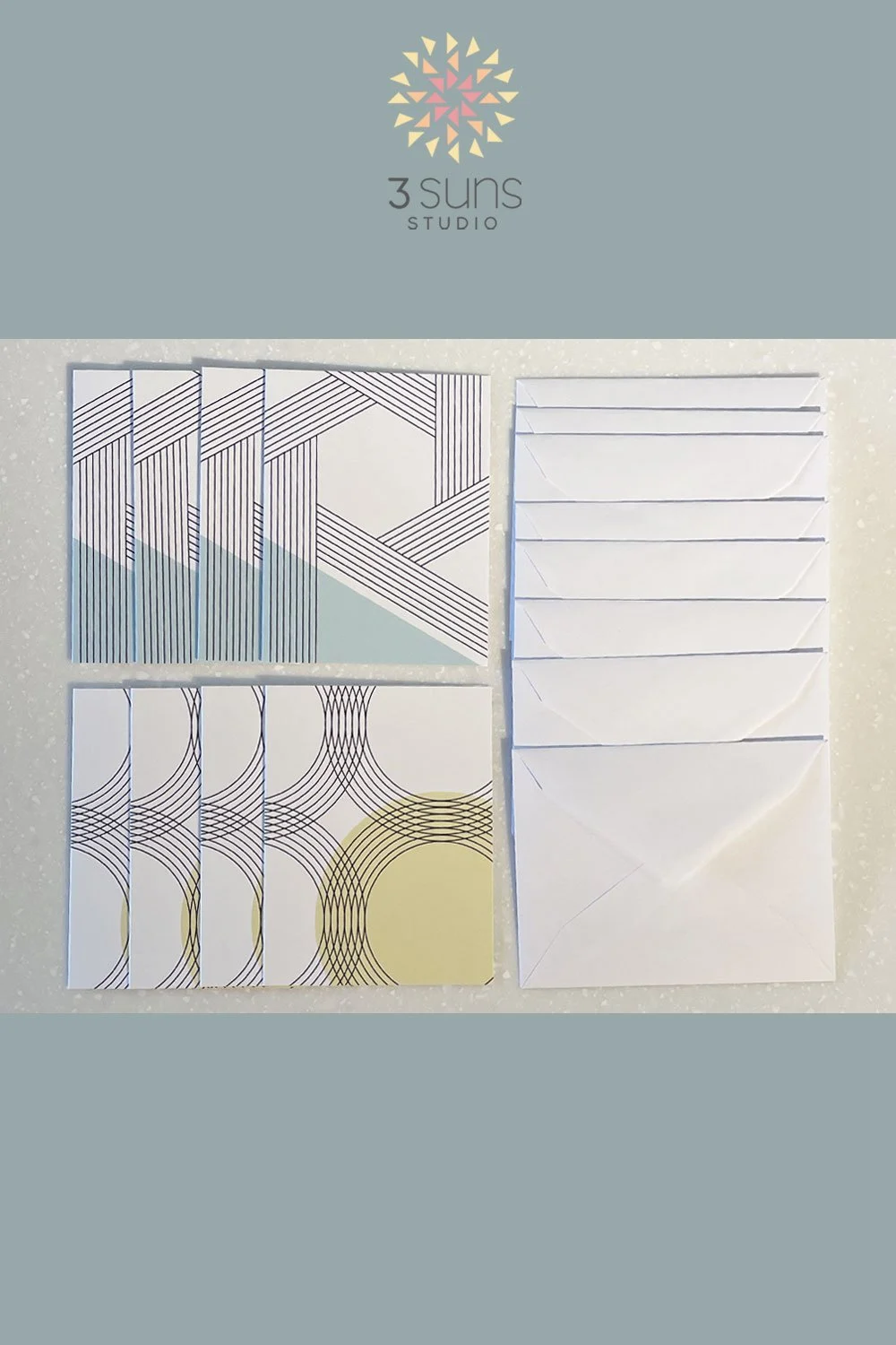 Set of 8 blank notecards, featuring 2 linear abstract designs. Includes 8 white envelopes.
