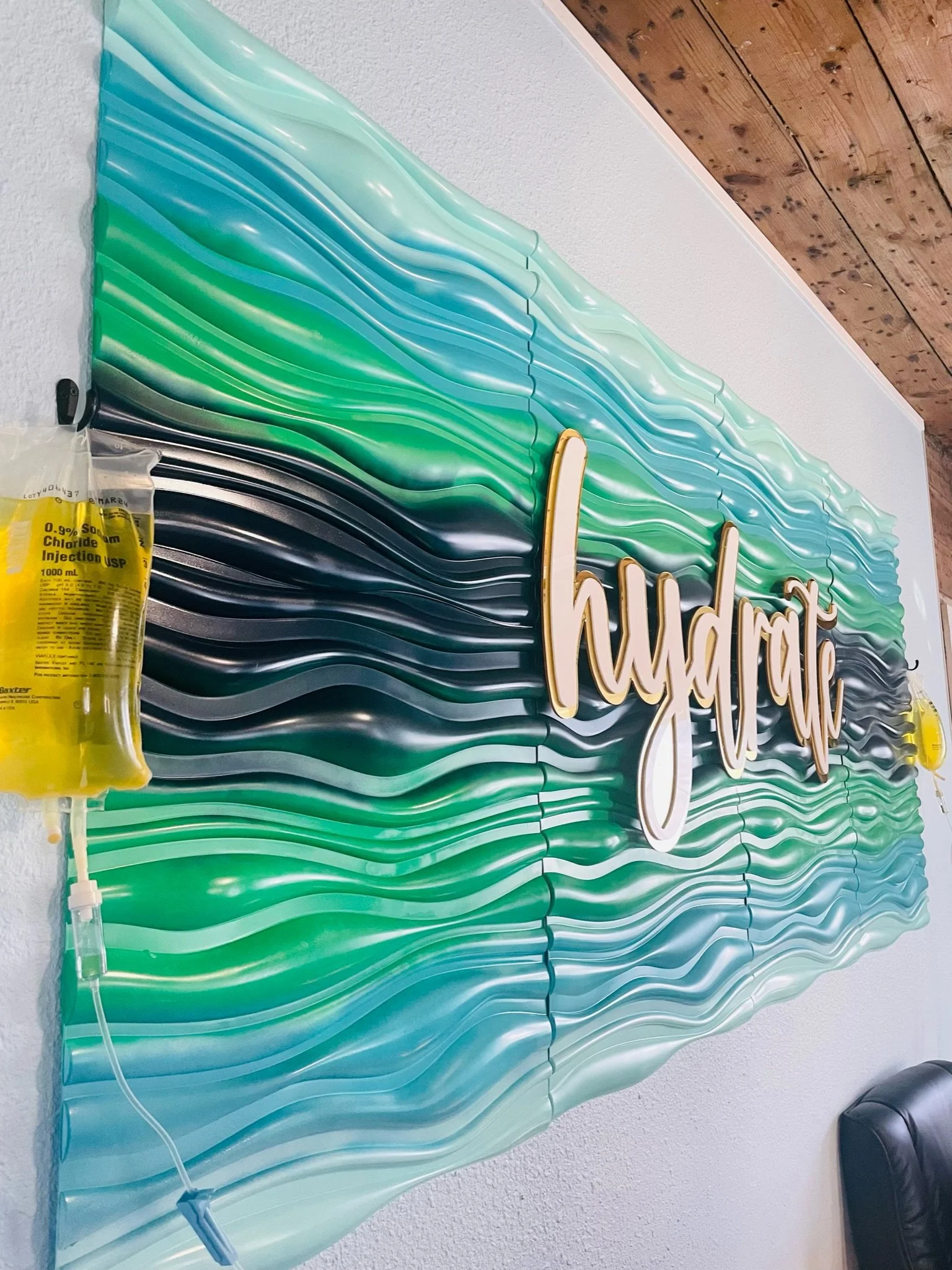 2 vitamin IV infusions hanging on the wall with "hydrate" sign at The Irenic Place in Aledo
