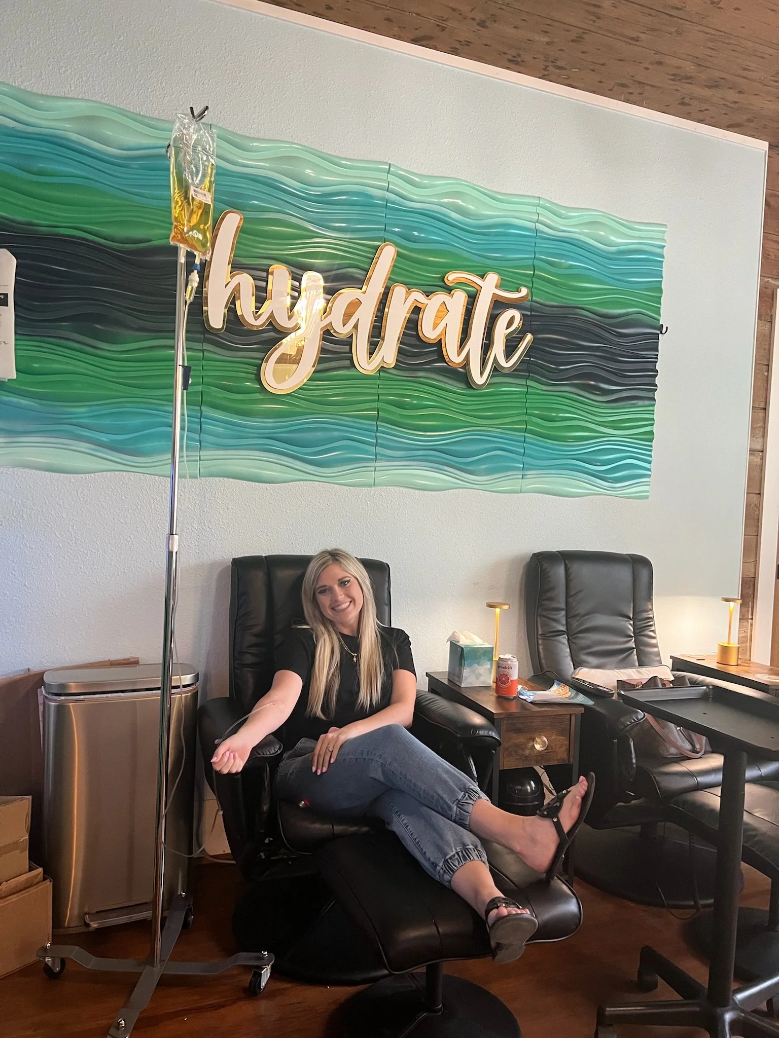 Smiling woman getting a vitamin IV infusion at The Irenic Place in Aledo, Texas