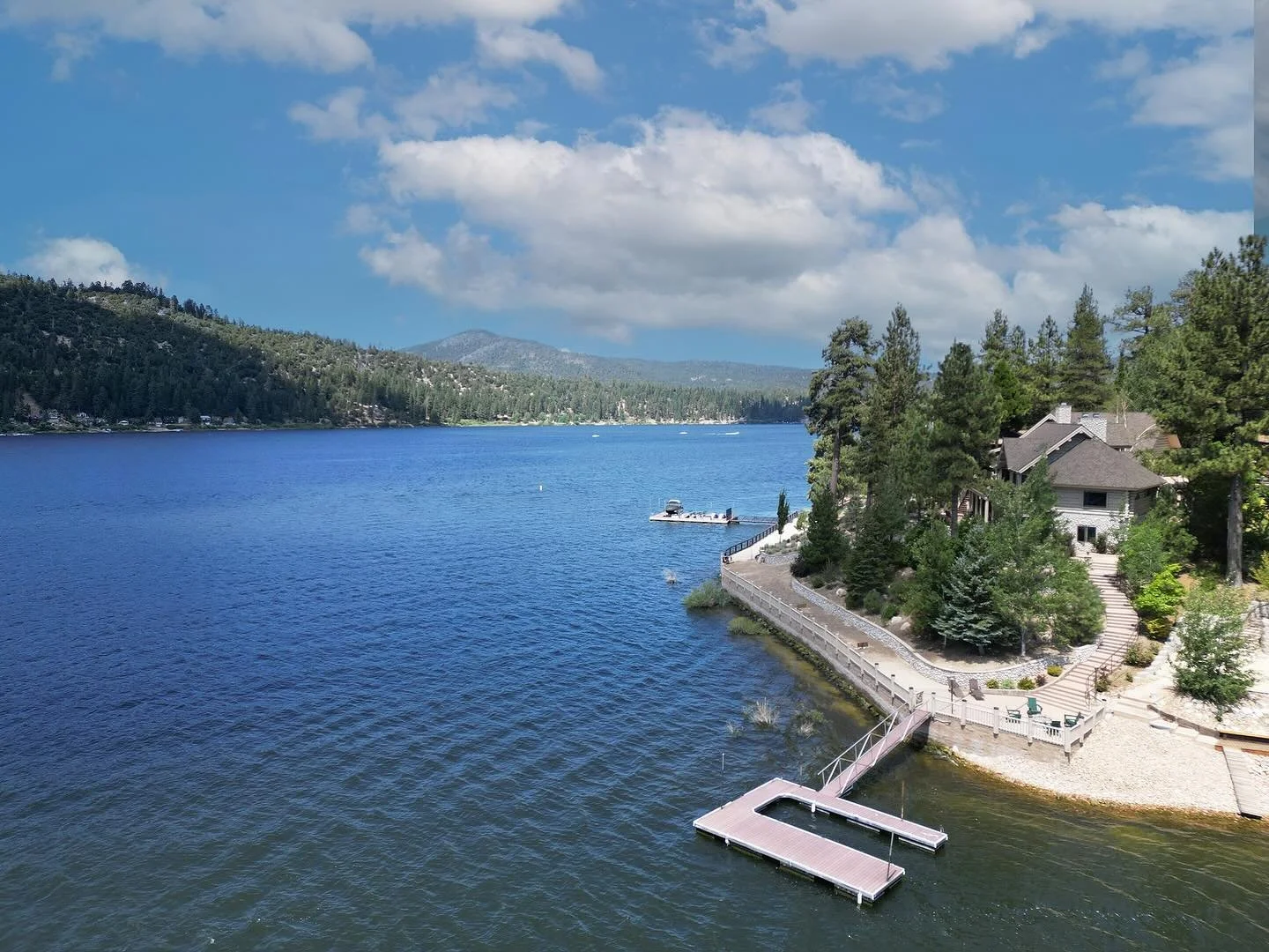 The ultimate Big Bear vacation rental - right on the lake with a boat dock, fire pit, hot tub and the coziest log cabin interior. #airbnbbigbear #airbnb #strbigbear #vacationrentallake #vacationrentalbigbearlake #bigbearlake #realestatephotography #b