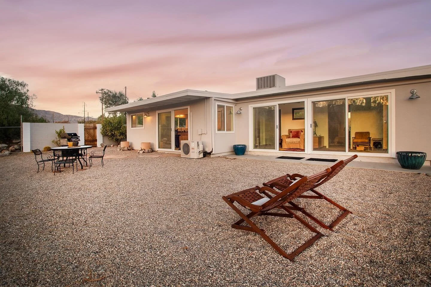 A newly renovated short term rental, centrally located between Joshua Tree and Palm Springs! The interior is newly renovated and has 2 bedrooms and 2 bathrooms. Fruiting olive and pomegranate trees line the driveway and the sun sets just behind the m