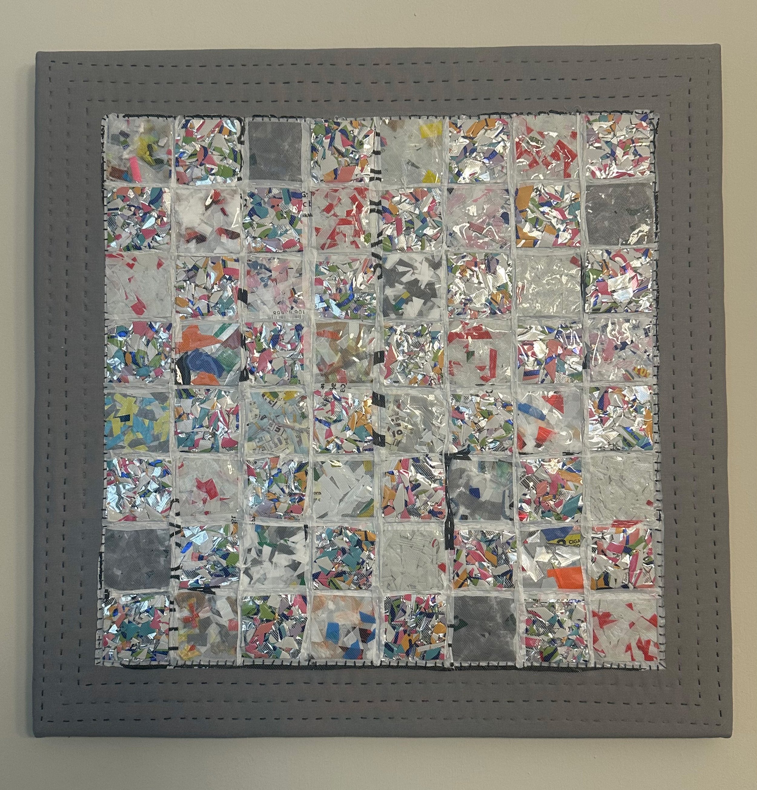 Up, up, and a waste. Collaged single use plastic bags and mylar balloons. Hand stitched.  Stretched on canvas. 20" x 20"