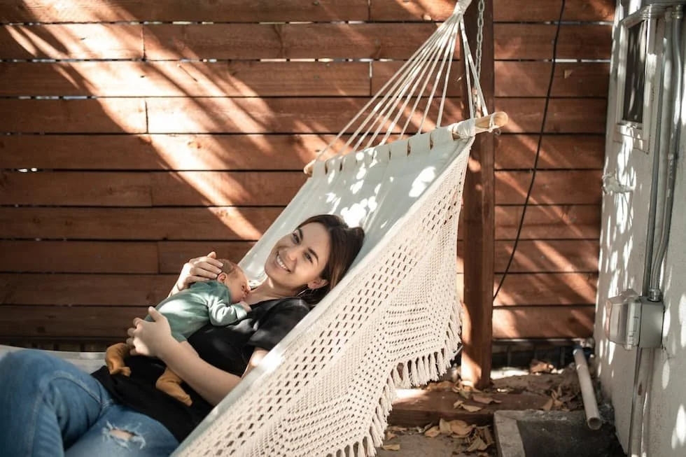 woman-in-green-t-shirt-lying-on-blue-hammock