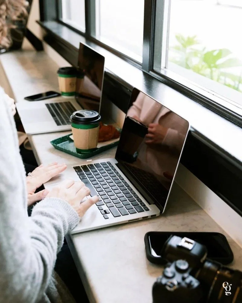 Laptops and coffee on a shared workspace, showing modern work habits beyond the best place to grow your brand.