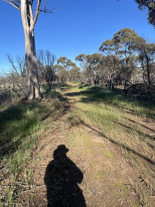 Shadow self portrait walking dirt road