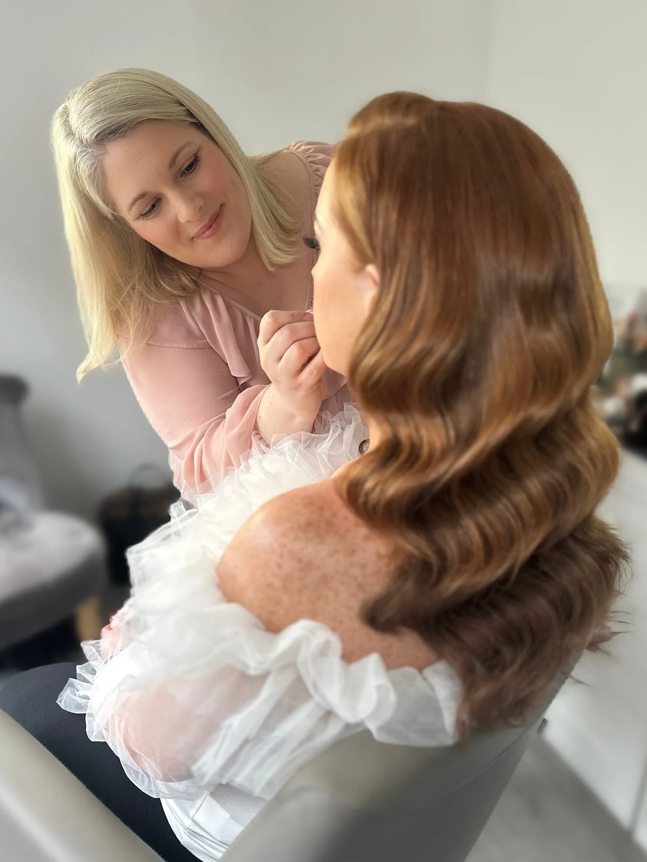 Bridal makeup artist touching up lipstick with Charlotte Tilbury- red head bride with hollywood wave- the bridal collective in cambridgeshire