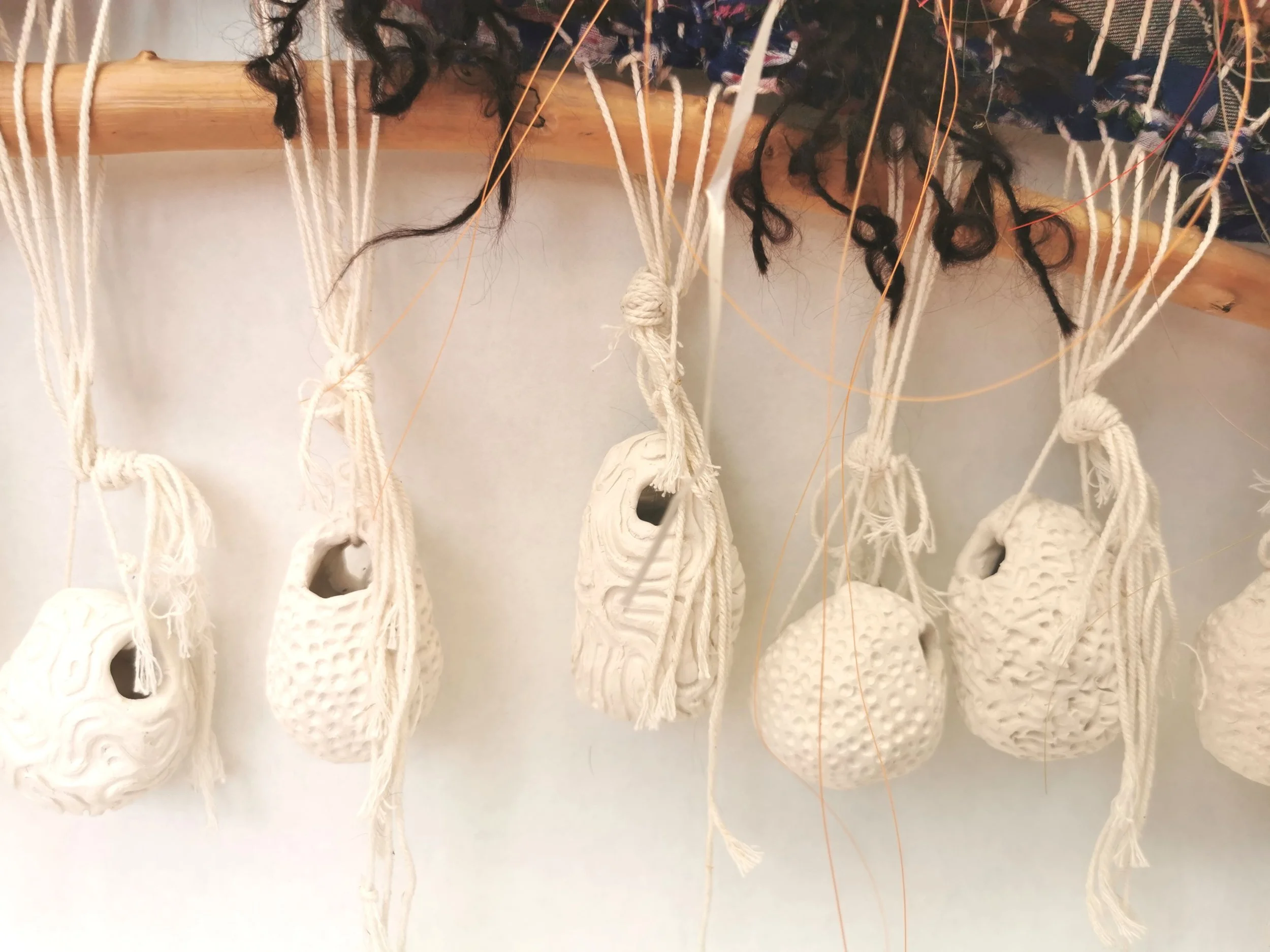 'Weaving Migrants' A year long research into the artists ancestors, from ancient royalty  to the Huguenot weavers. 
Image: Plastic Reef. Woven recycled fabric scraps, yarn, monofilament fishing line and found object, ceramic loom weights.