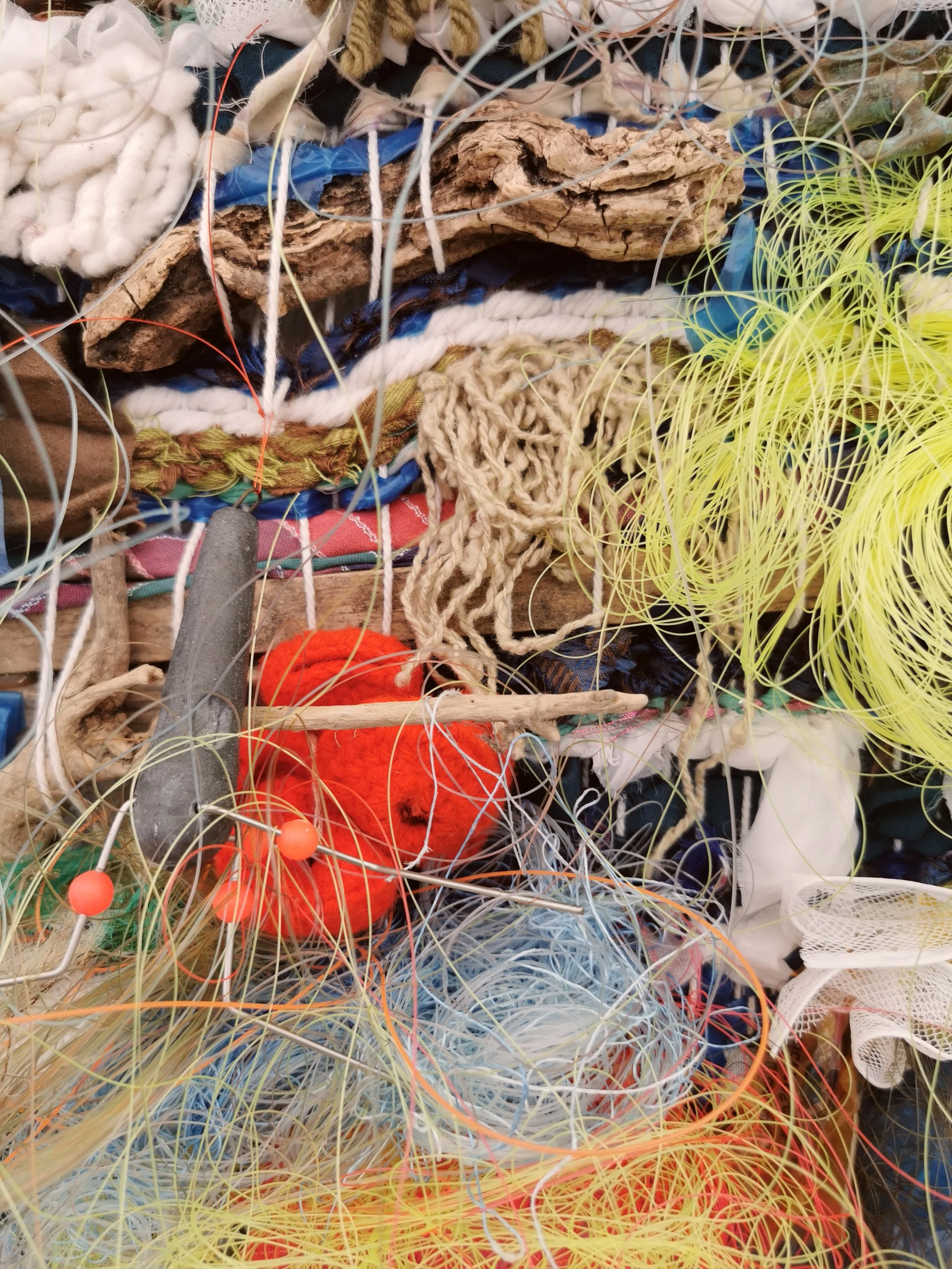 'Weaving Migrants' A year long research into the artists ancestors, from ancient royalty  to the Huguenot weavers. 
Image: Plastic Reef. Woven recycled fabric scraps, yarn, monofilament fishing line and found object, ceramic loom weights.