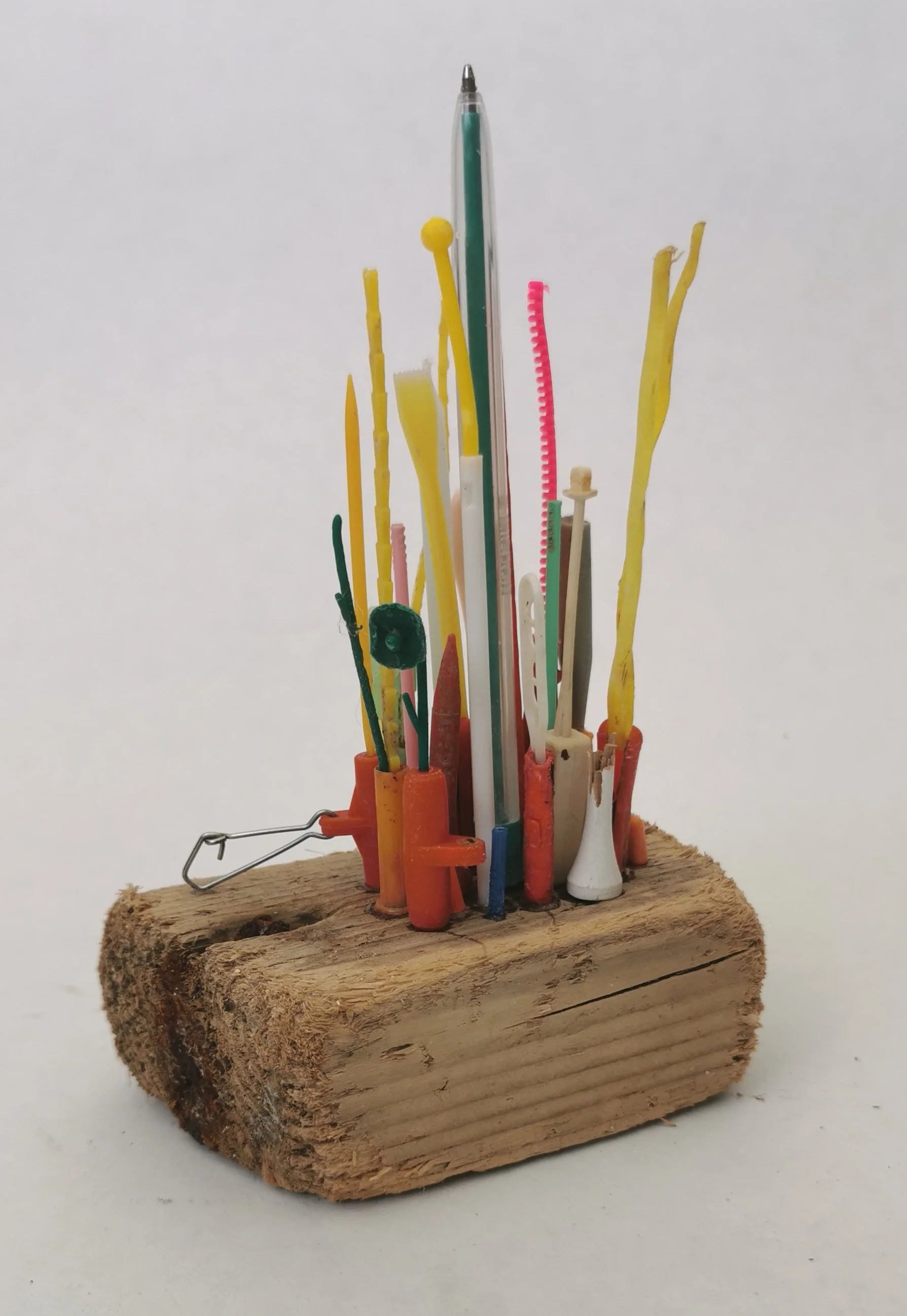 'Plastic Islands' Collected microplastic pieces assembled into miniature high rise cities perched precariously on driftwood islands, a comment on marine plastic and coastal erosion.