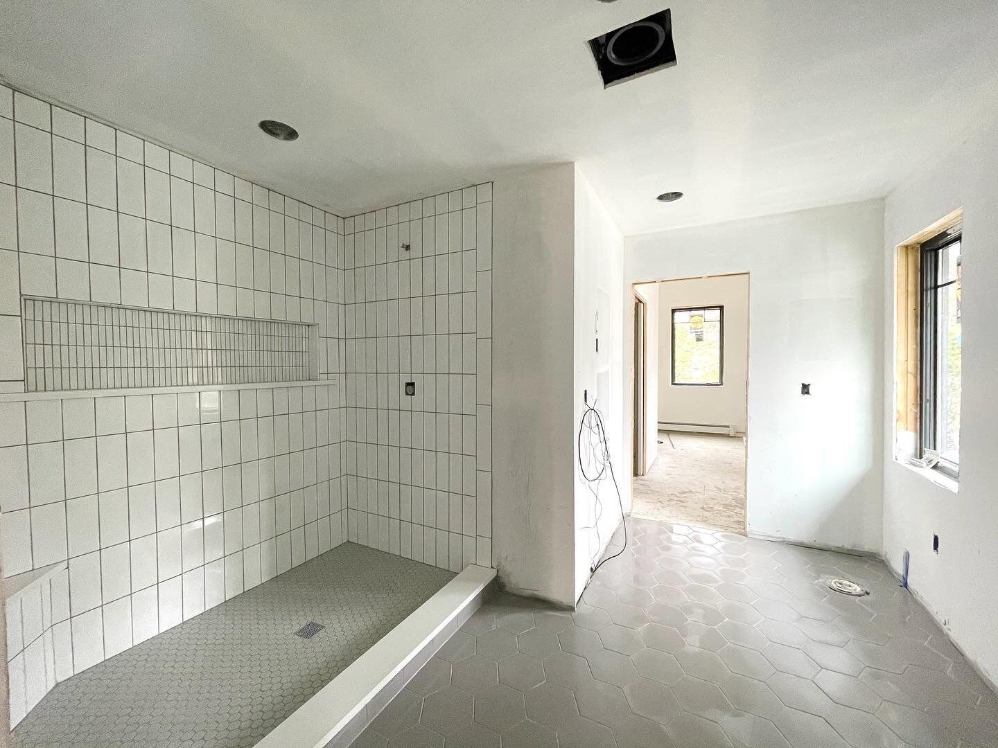 Tile is done and this en-suite is quickly becoming one of our favorite spaces at our Lakeview project! Natural light, simple palette of colors and textures, and not to mention the dual shower heads and heated floors! Beyond is the walk-in closet. 

#