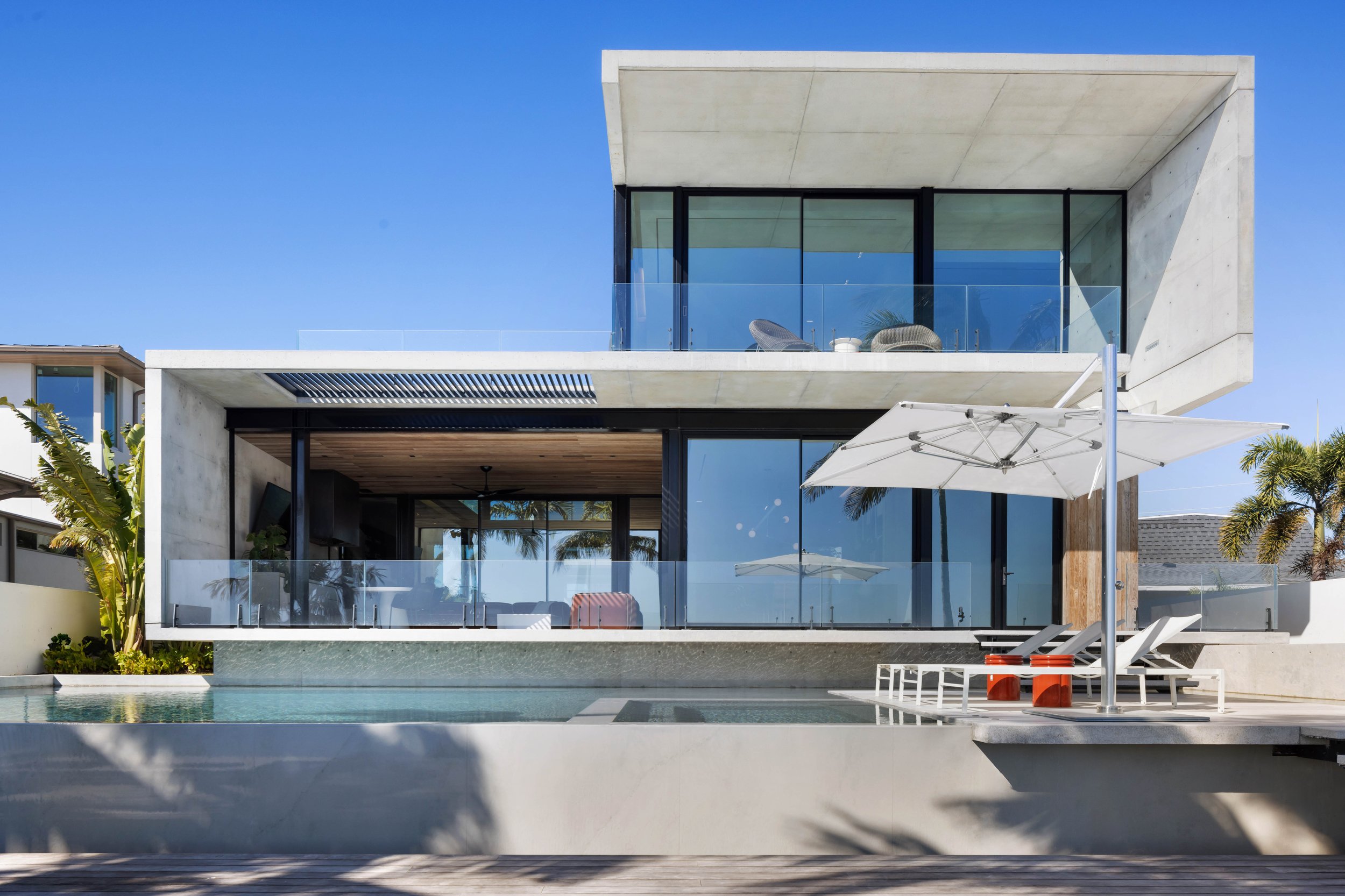 In-yo a Modern concrete waterfront residence in Lido Shores, Sarasota, designed by Hive Architects with an elevated structure and contemporary detailing.