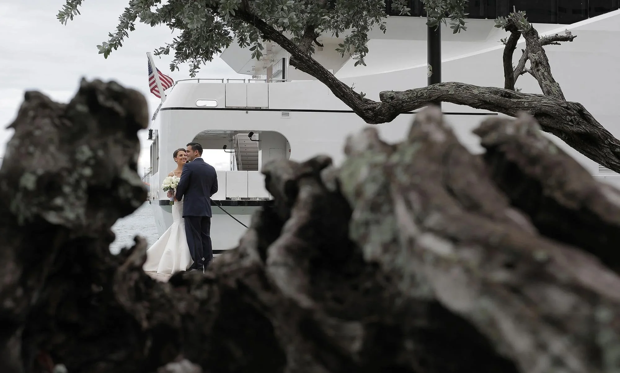 Wedding couple by a pier and boat captured for a cinematic wedding film