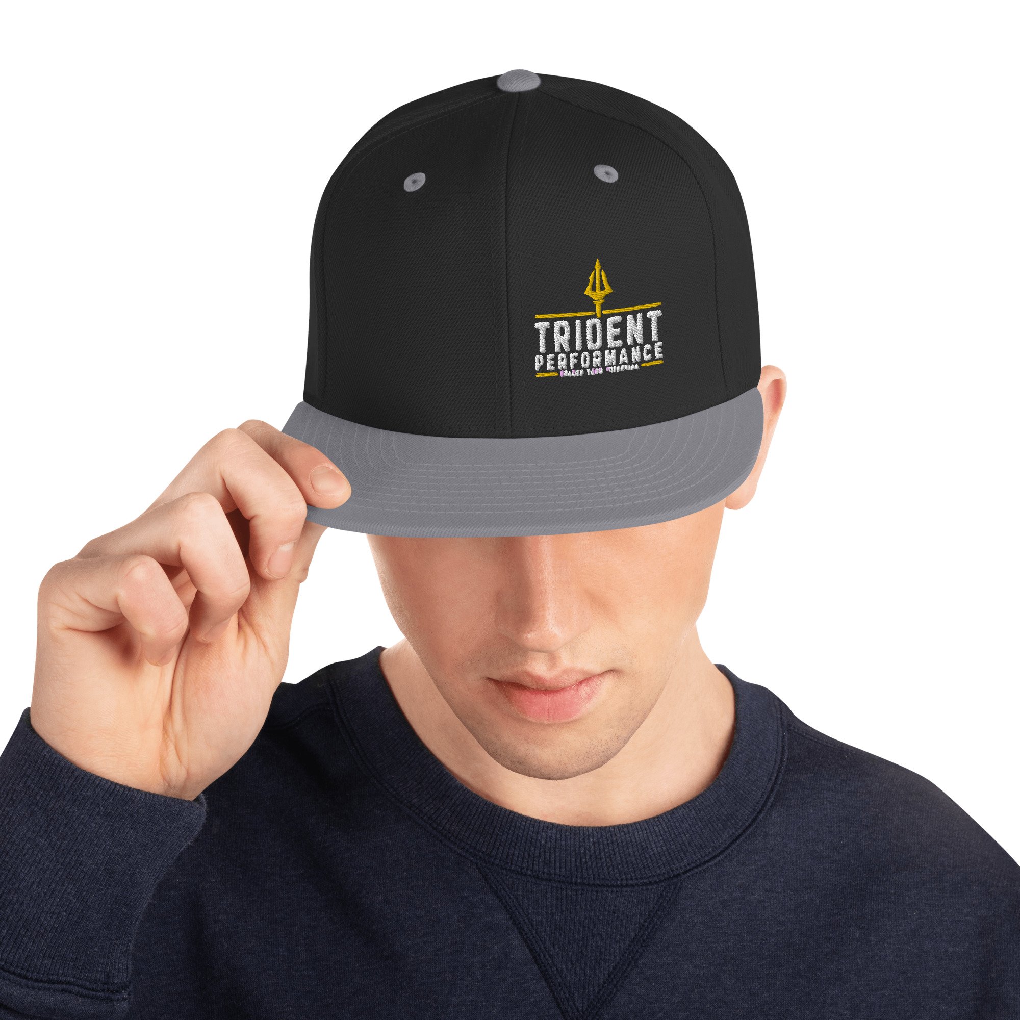 Black snapback hat with embroidered Trident Performance logo and Unlock Your Potential tagline