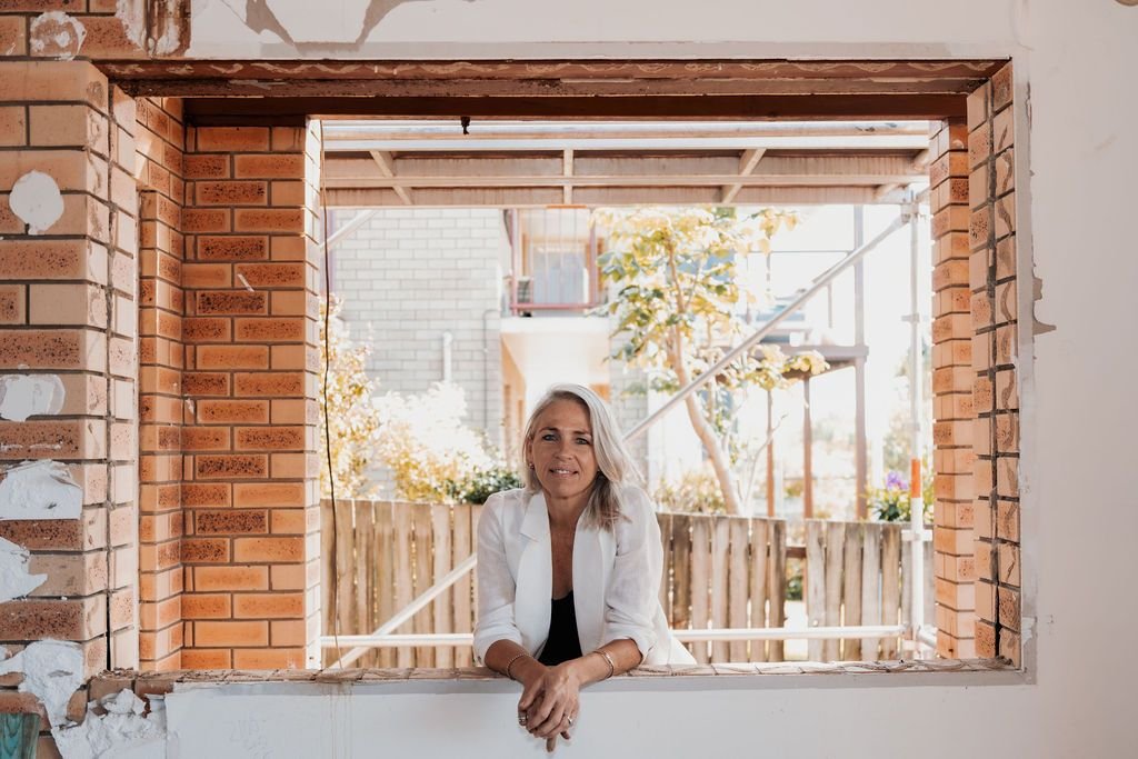 Sarah Wood  on a windowsill on the building site.