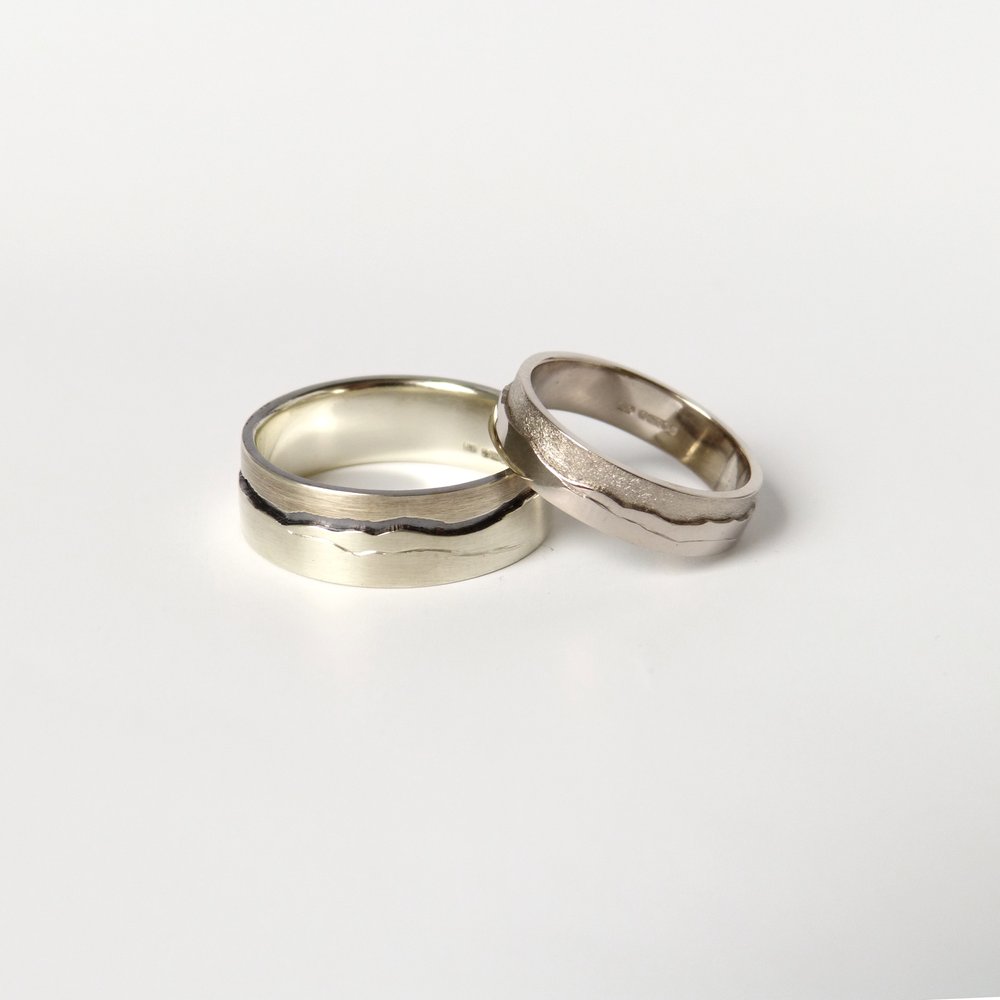 9ct and 18ct white gold wedding rings with the landscape seen from Orrest head. 