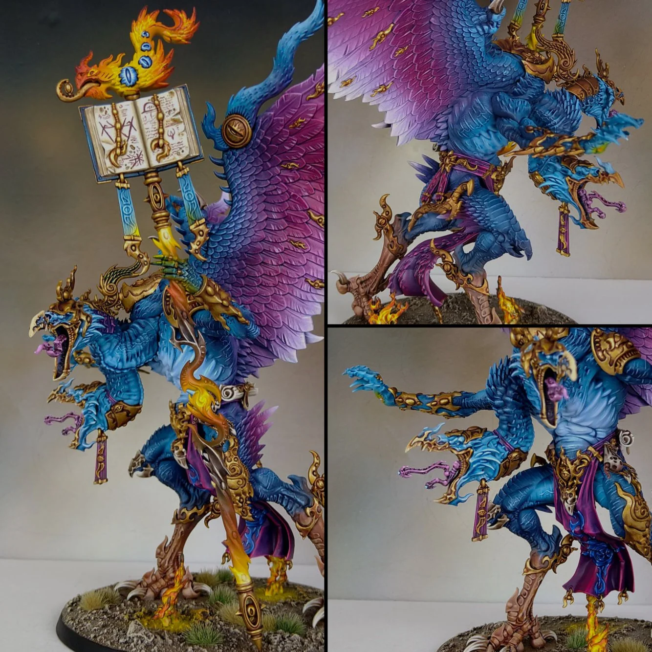 Colorful fantasy miniature figurine of a fierce, winged dragon with blue and purple scales, adorned with gold armor and accessories. The dragon is standing on a detailed base with grass and flames, holding an open magic book with floating symbols, an