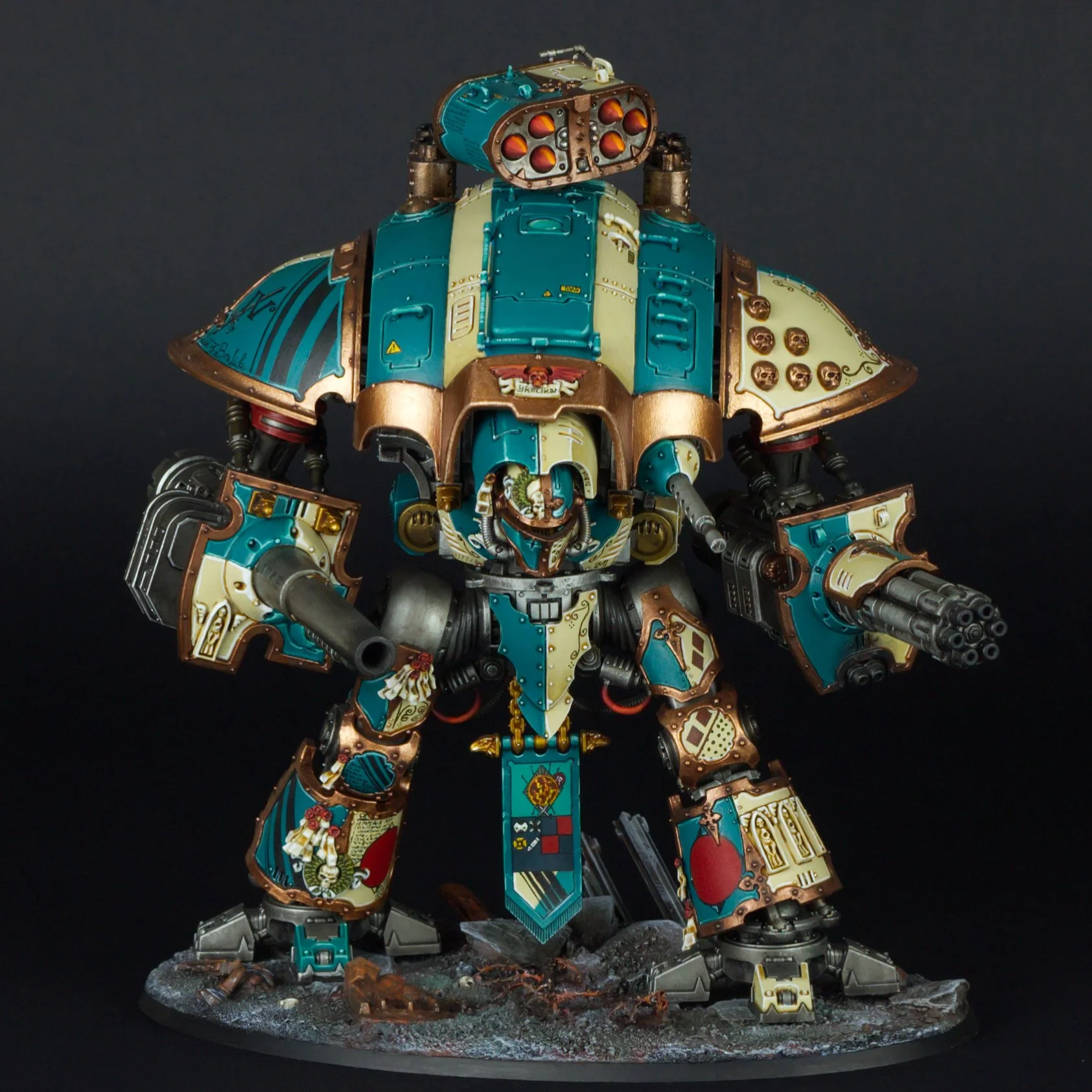 A detailed model of a painted robot with a vintage, pinup style design, standing on a textured base. The robot features a teal and beige color scheme with brown and gold accents, and various symbols and artwork on its armor.
