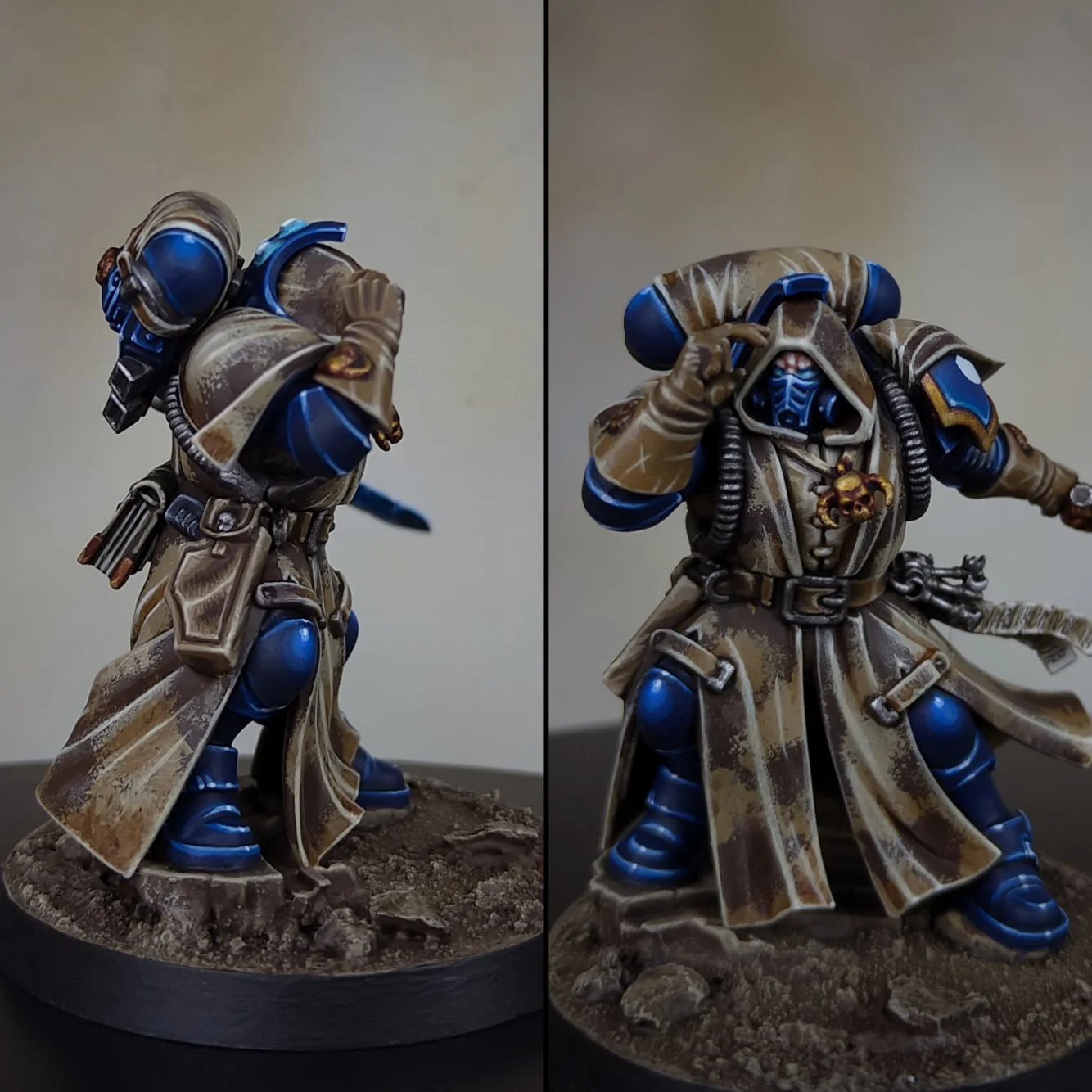 Miniature model of a sci-fi soldier wearing a hooded cloak with blue armor accents, detailed with skull jewelry, and posing on a textured base.