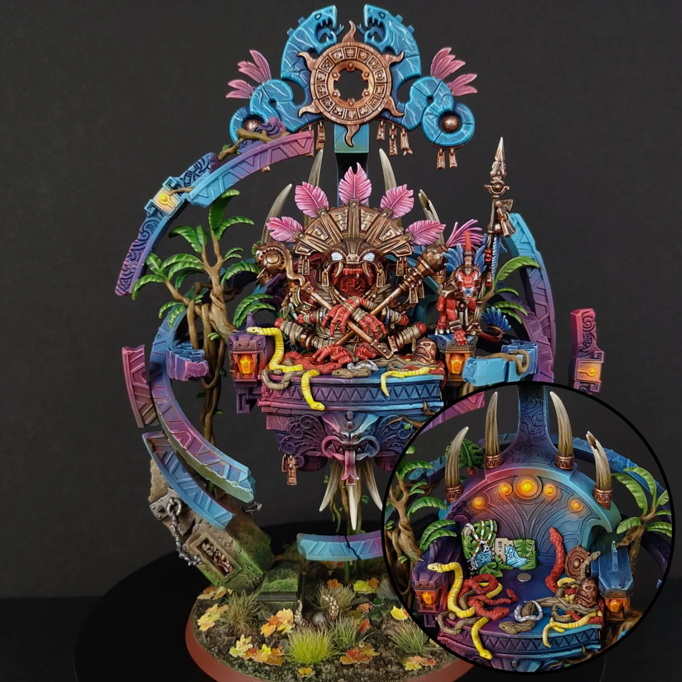 Colorful figurine of a tribal deity with horns and a staff, sitting on a platform with a snake in the background and surrounded by plants and trees, part of a miniature diorama with intricate details.