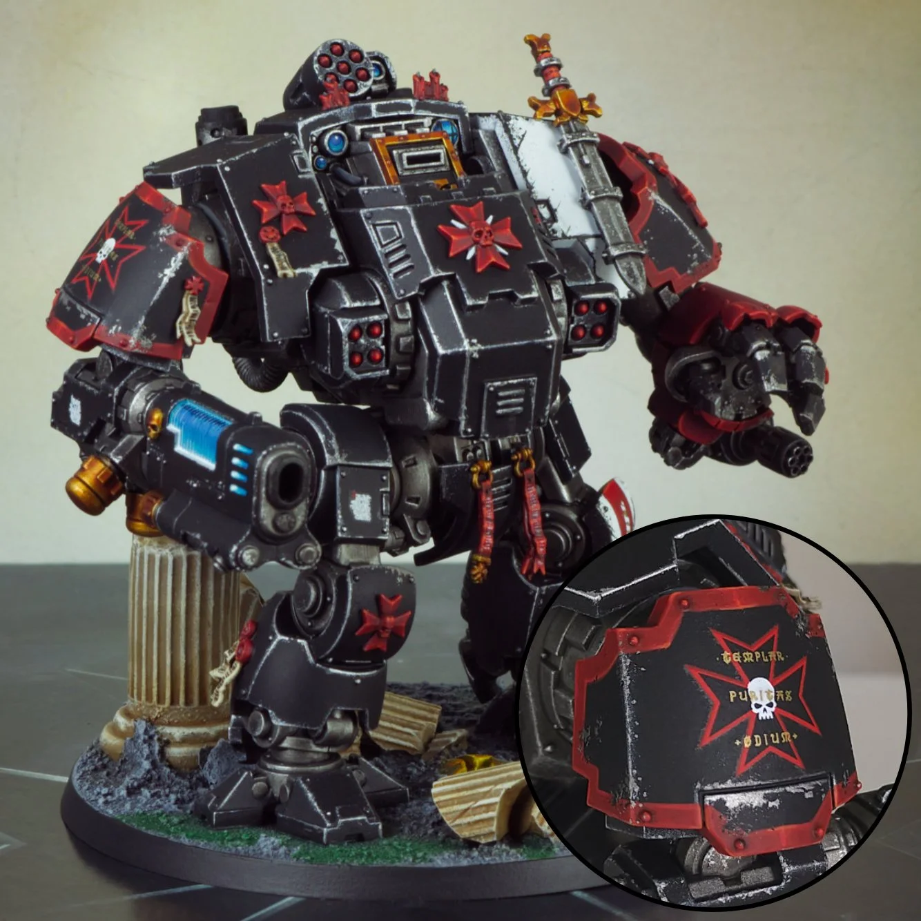 A detailed model of a Warhammer 40K Space Marine Dreadnought painted in black and red with weathered effects, standing on a diorama base decorated with debris and wooden ruins.