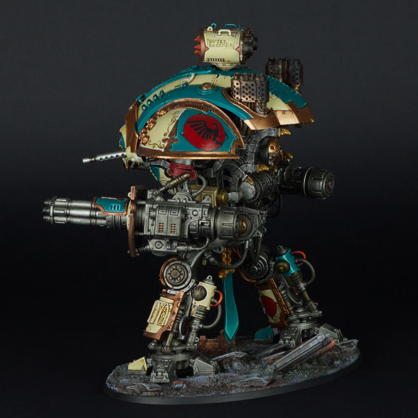A detailed model of a robotic humanoid figure with a large, rounded body and limbs, painted in teal, cream, gold, and red accents, standing on a rocky base against a black background.