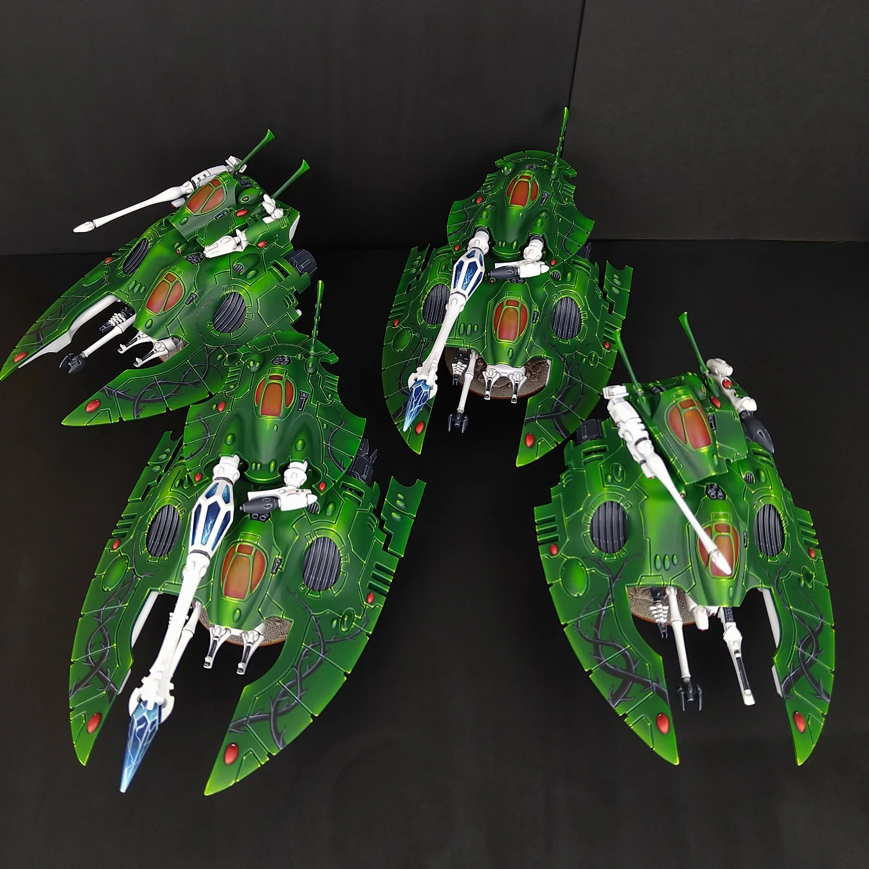 Green insect-like spaceship model with white and black mechanical parts on a black background.
