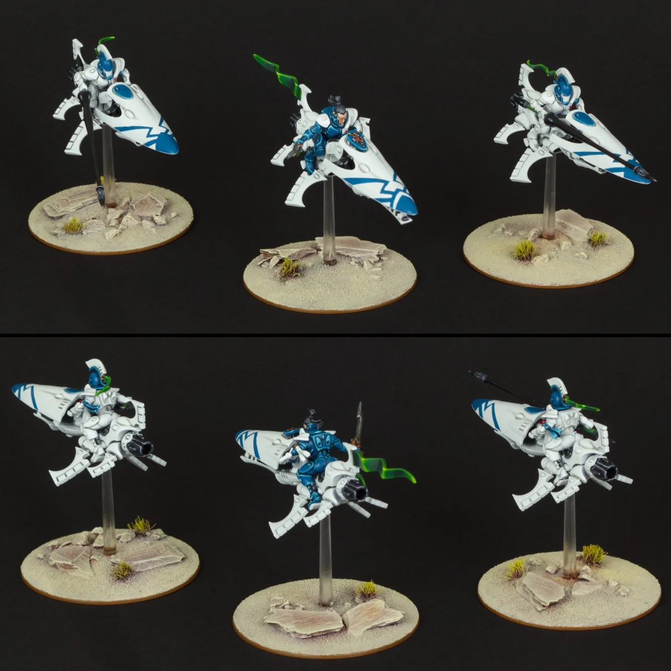 Six miniature science fiction figures resembling futuristic soldiers or pilots, with vehicles mounted on small bases, set against a black background. The figures are painted predominantly white with blue accents and one features green elements, displ