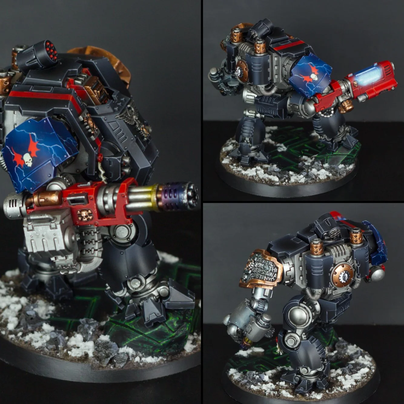Painted miniature figurine of a robotic war machine with a large gun, painted in black, red, and blue with a winged skull symbol, standing on a round base with snow and green circuit pattern.