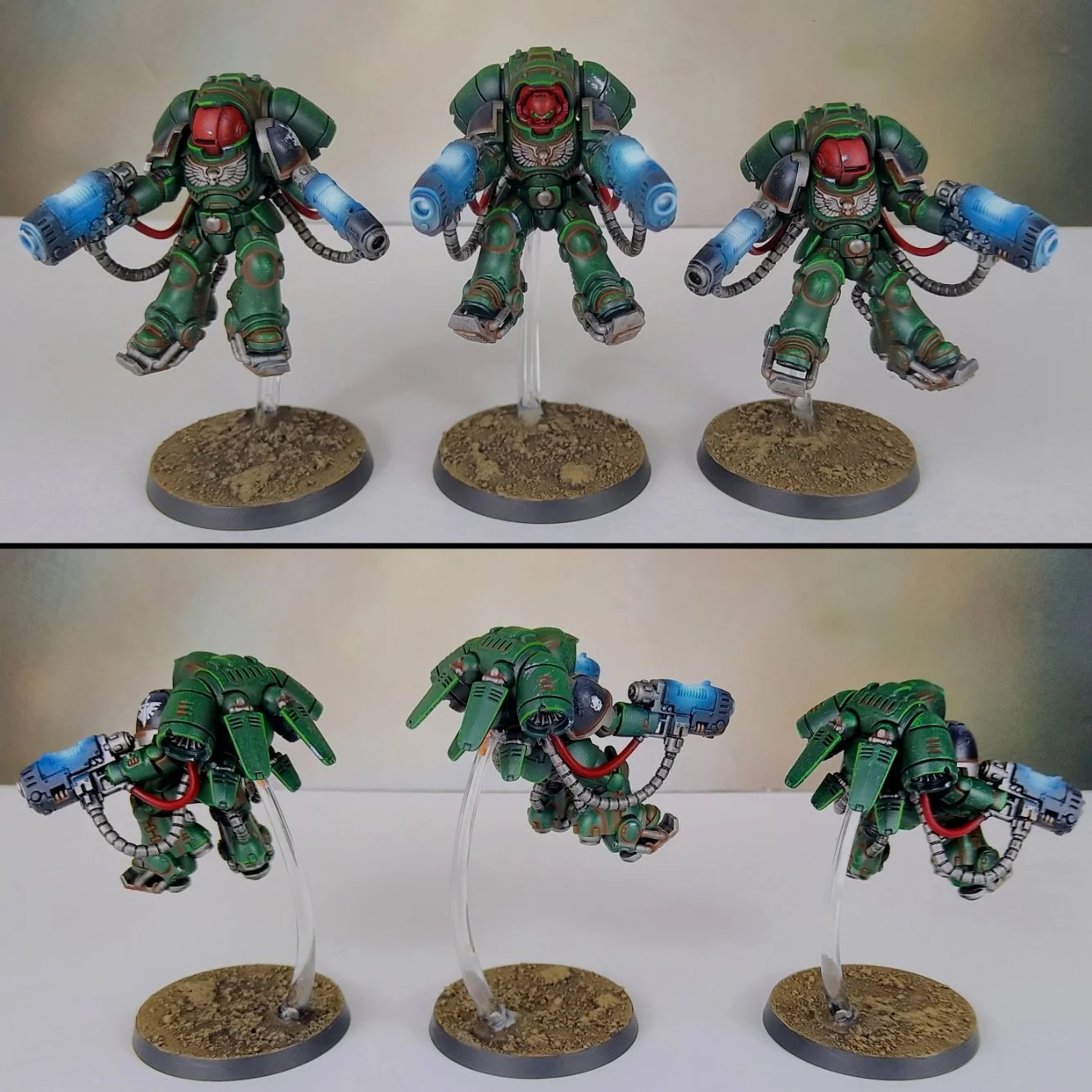 Miniature models of green armored soldiers with red helmets and blue weapons, mounted on round bases with textured terrain, displayed from front and back angles.