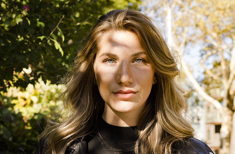 Headshot of a woman with trees with leaves behind her. Upstate New York Photographer.