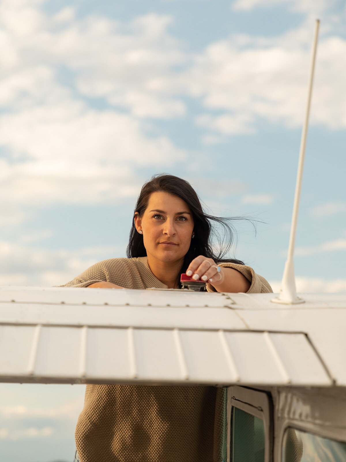 Portrait of a female pilot checking the gas gauge in her plane. Upstate New York Photographer.