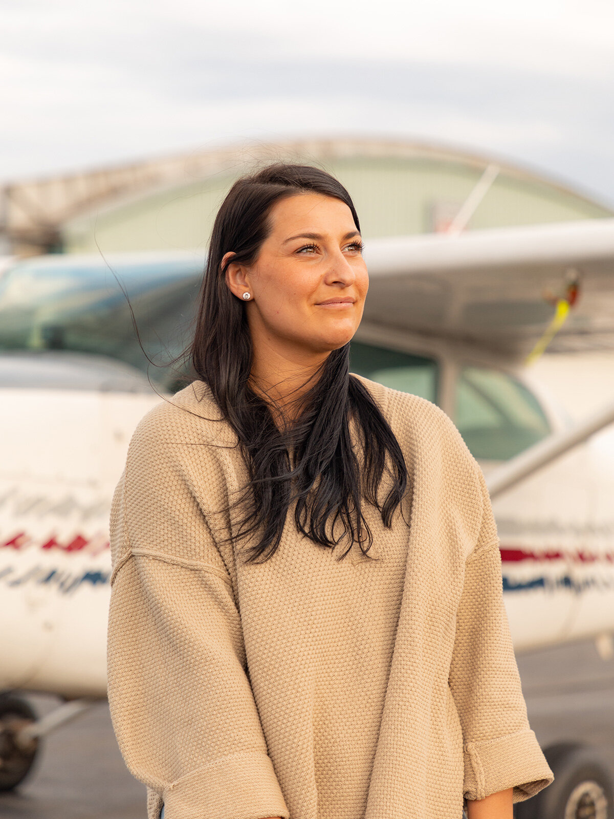Portrait of a female pilot with her plane in the background. Upstate New York Photographer.