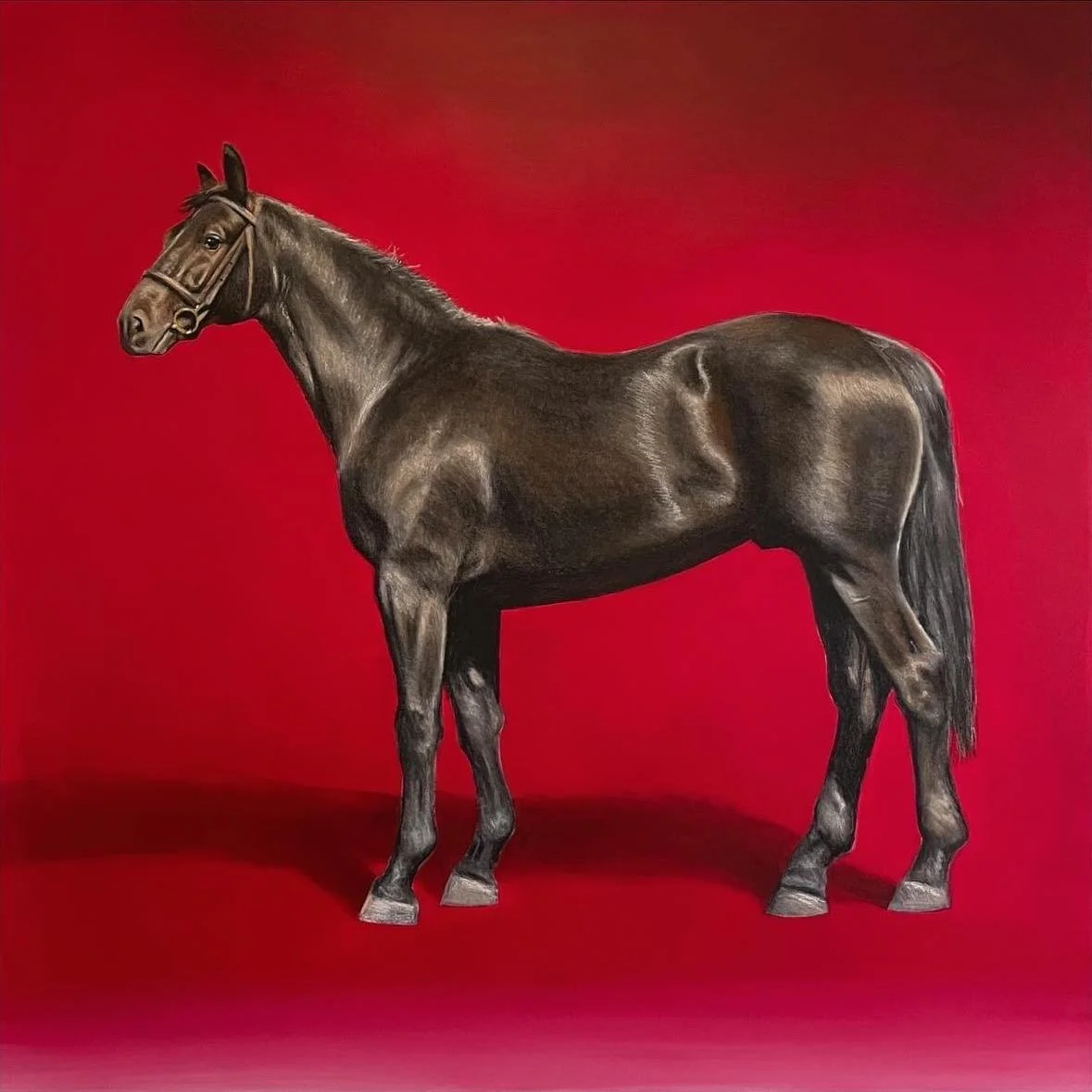 A realistic statue of a brown horse standing on a floor in front of a red background.
