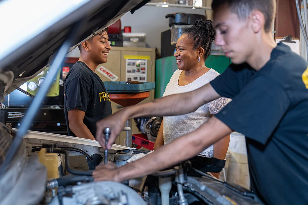 This mental health therapist is meeting with a teen next to a car.