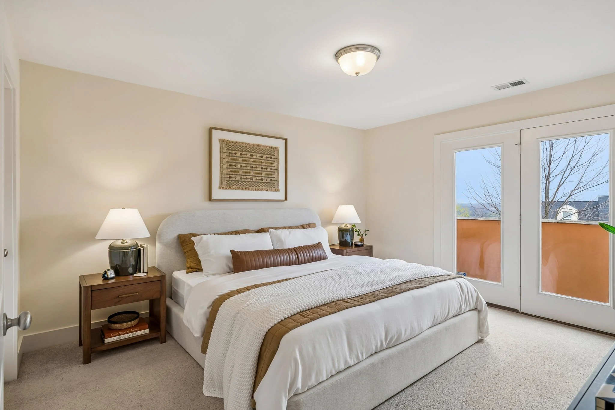 After Image of Bedroom Layered with Bed Nightstands Cozy Bedding Artwork Above Bed and Lamps on Nightstands