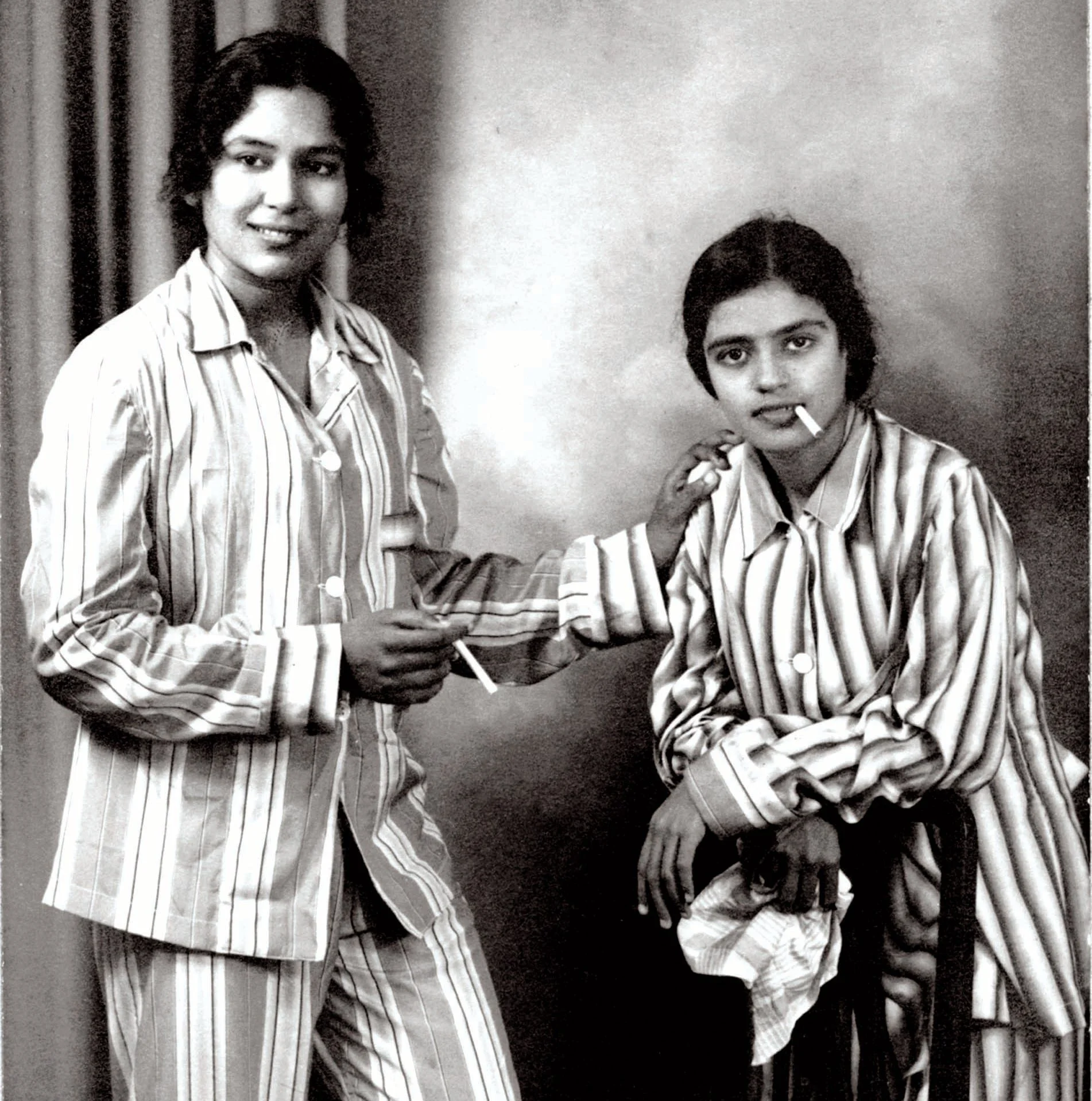photo of two people one standing and one sitting and smoking