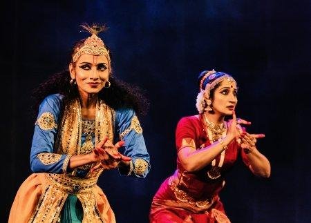 two femail dancers one in red and one in blue holding poses