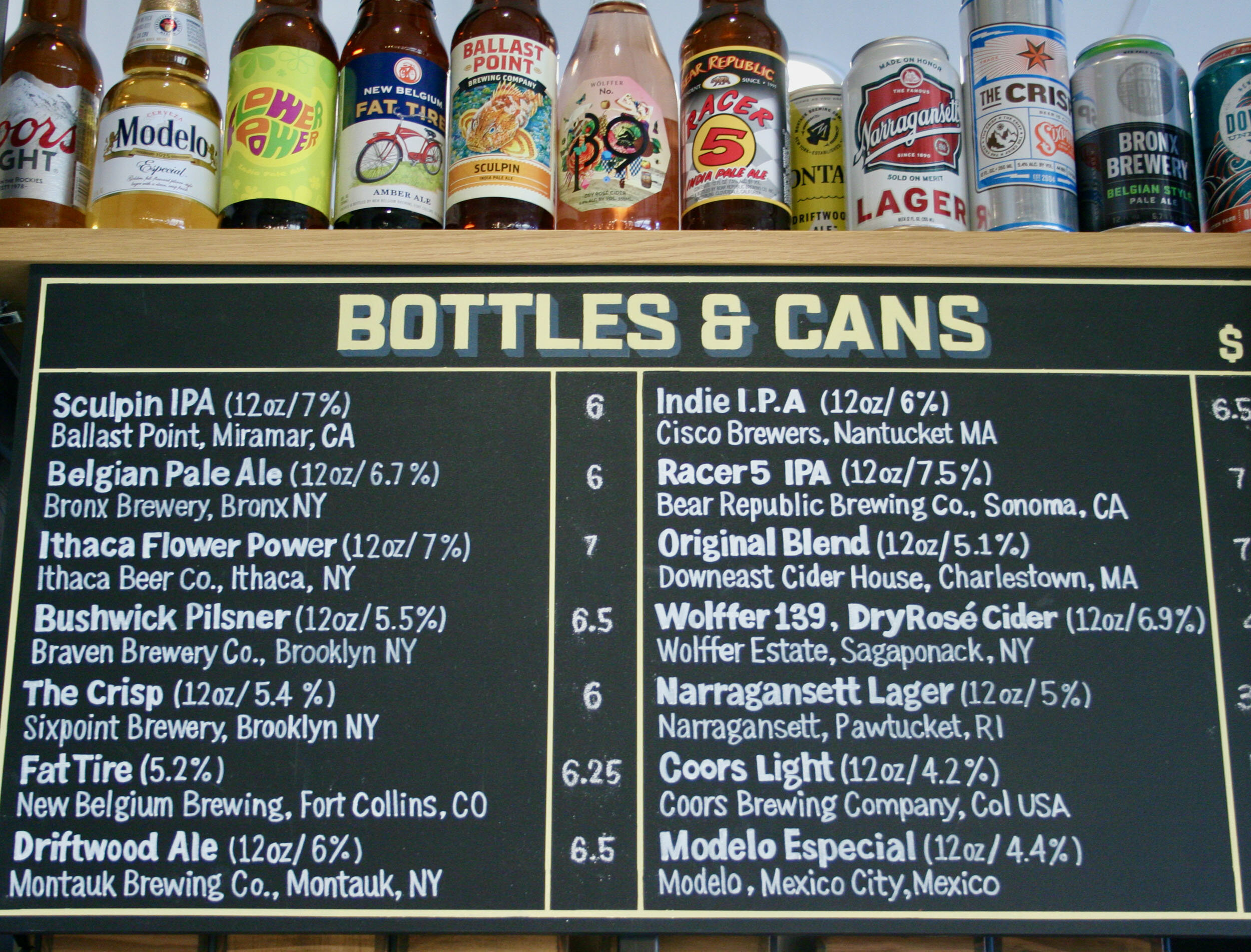In addition to draft beer, bottles and cans round out the offering, as shown on this hand-lettered blackboard.