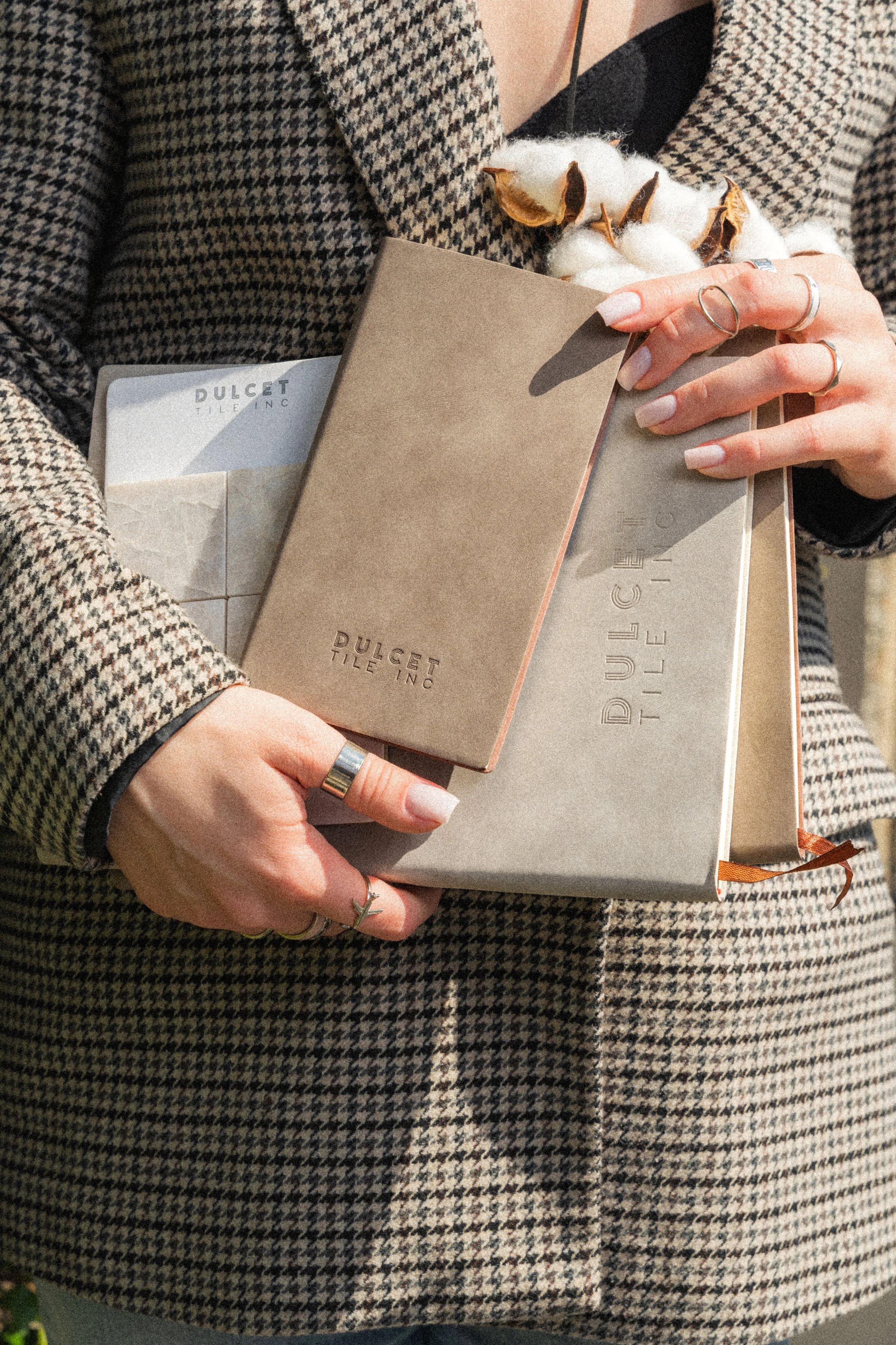 Close-up product photo of journals and notebooks being held with a moody brown aesthetic