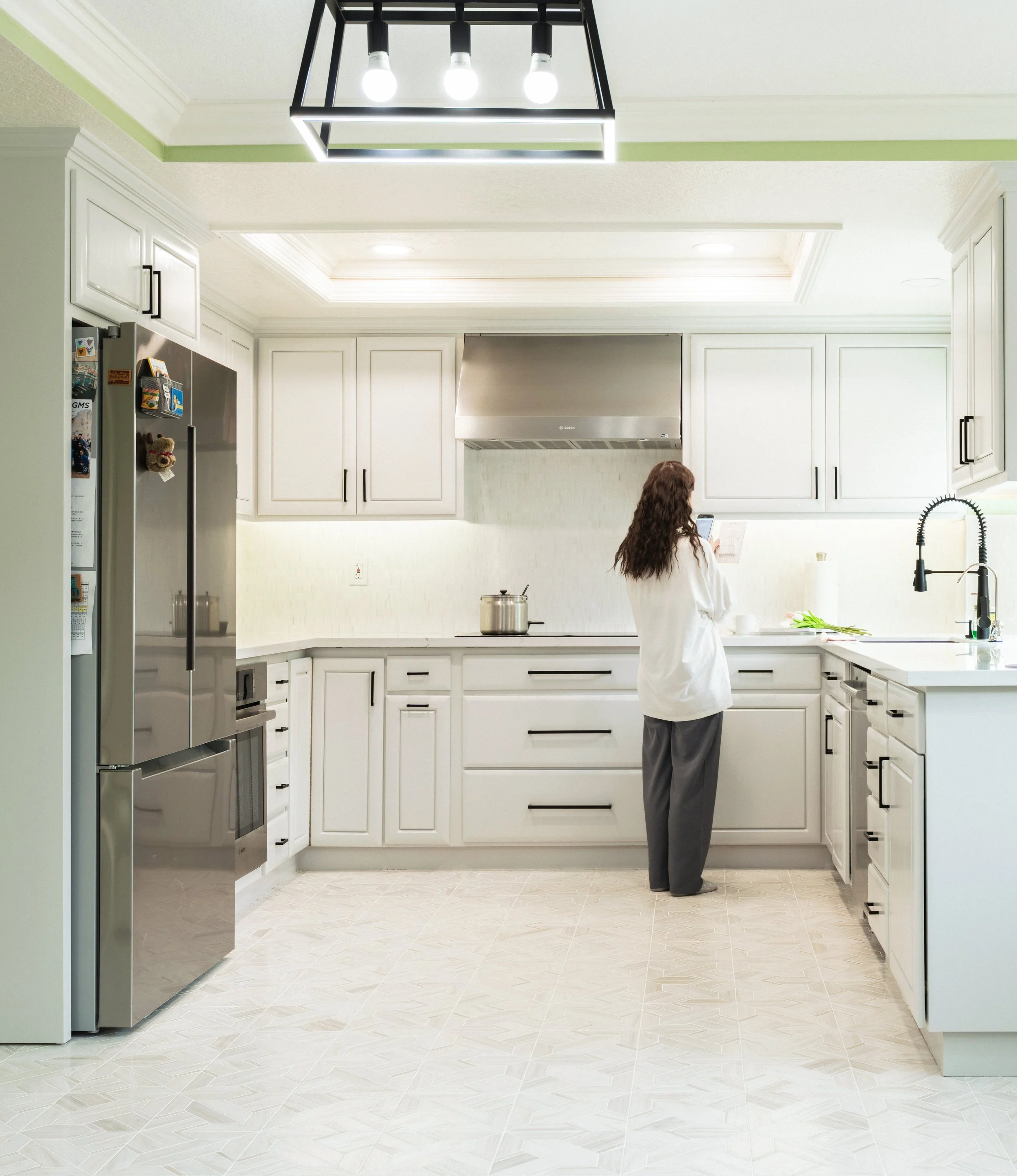 Orange County home's wide kitchen photo with bright whites and green ceiling