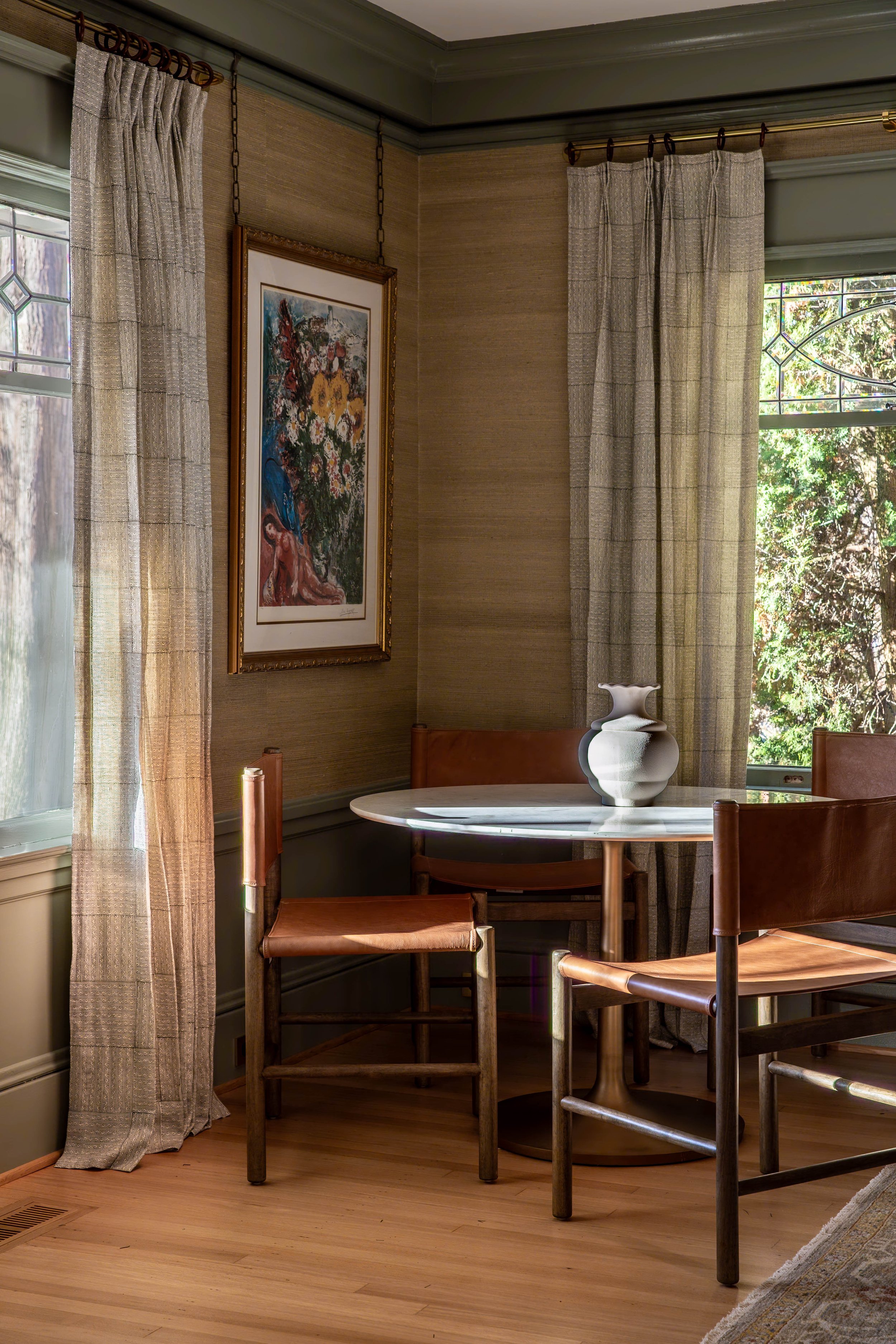 Warm dining room with leather chairs, marble table and layered natural textures designed by Ashley Kiely Living in Portland, Oregon.