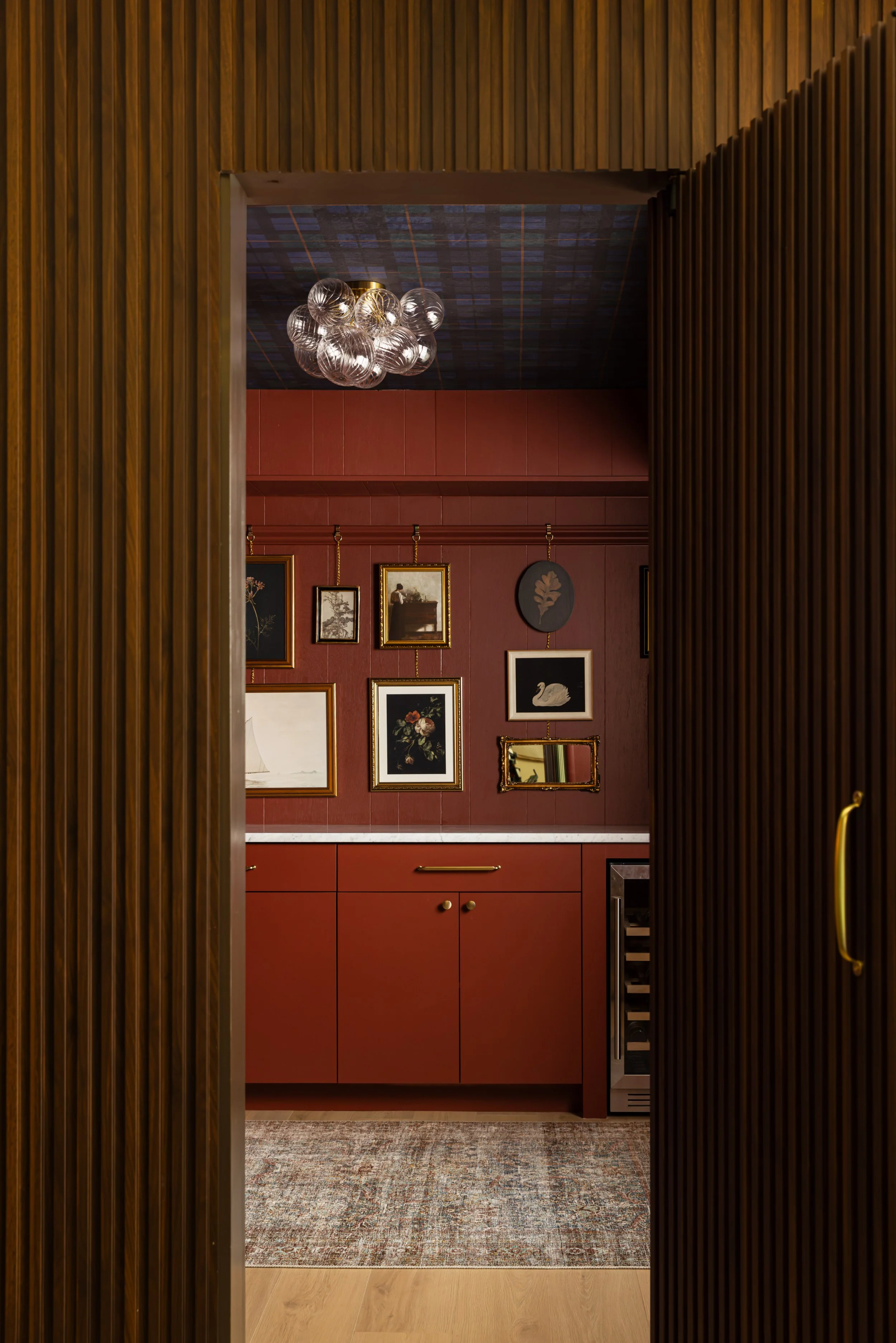 Open walnut slat Murphy door revealing the hidden speakeasy in the Canyon Lane lower-level remodel.