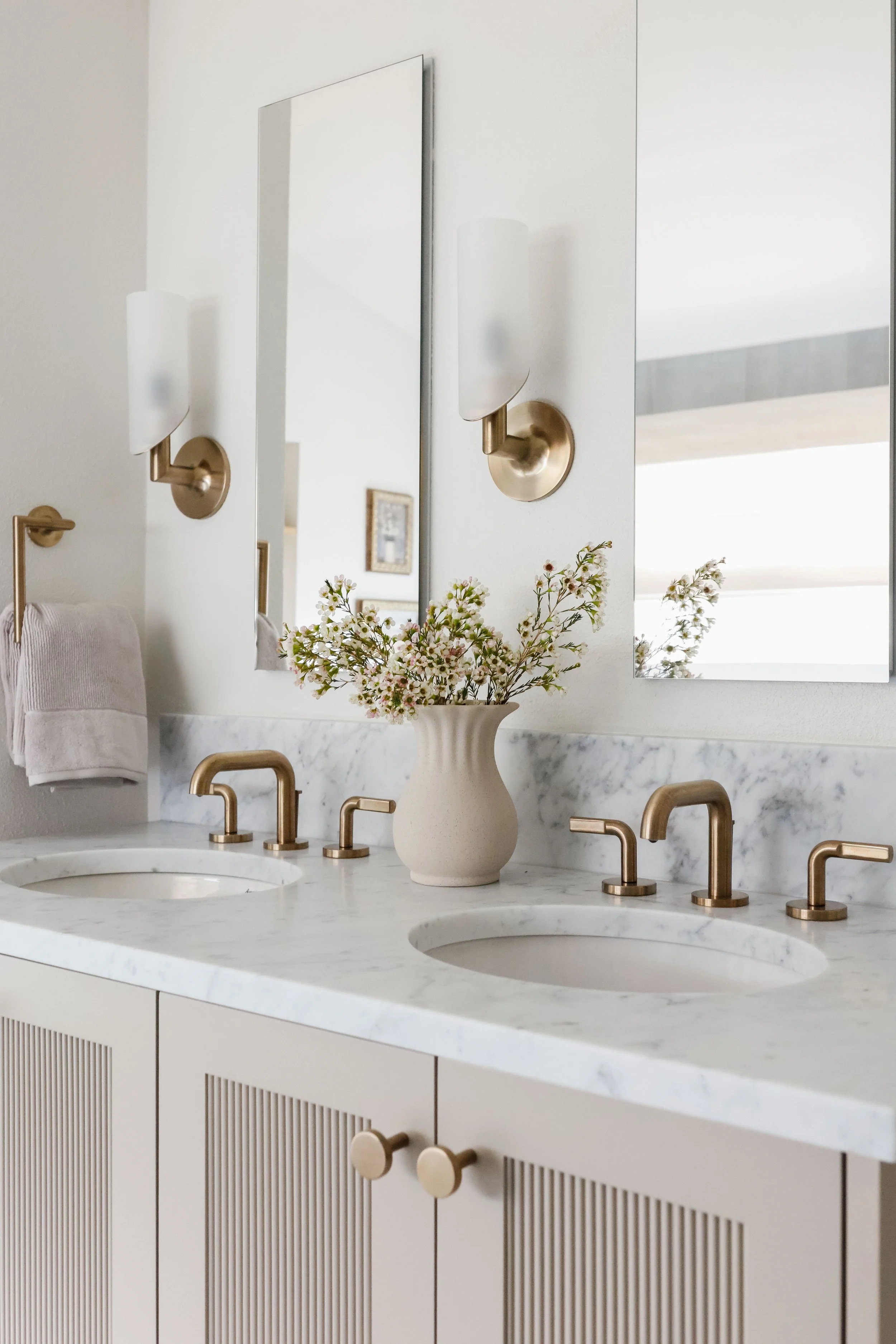 Primary bathroom with marble countertops, brass fixtures and custom vanity designed by Ashley Kiely Living in Portland, Oregon.