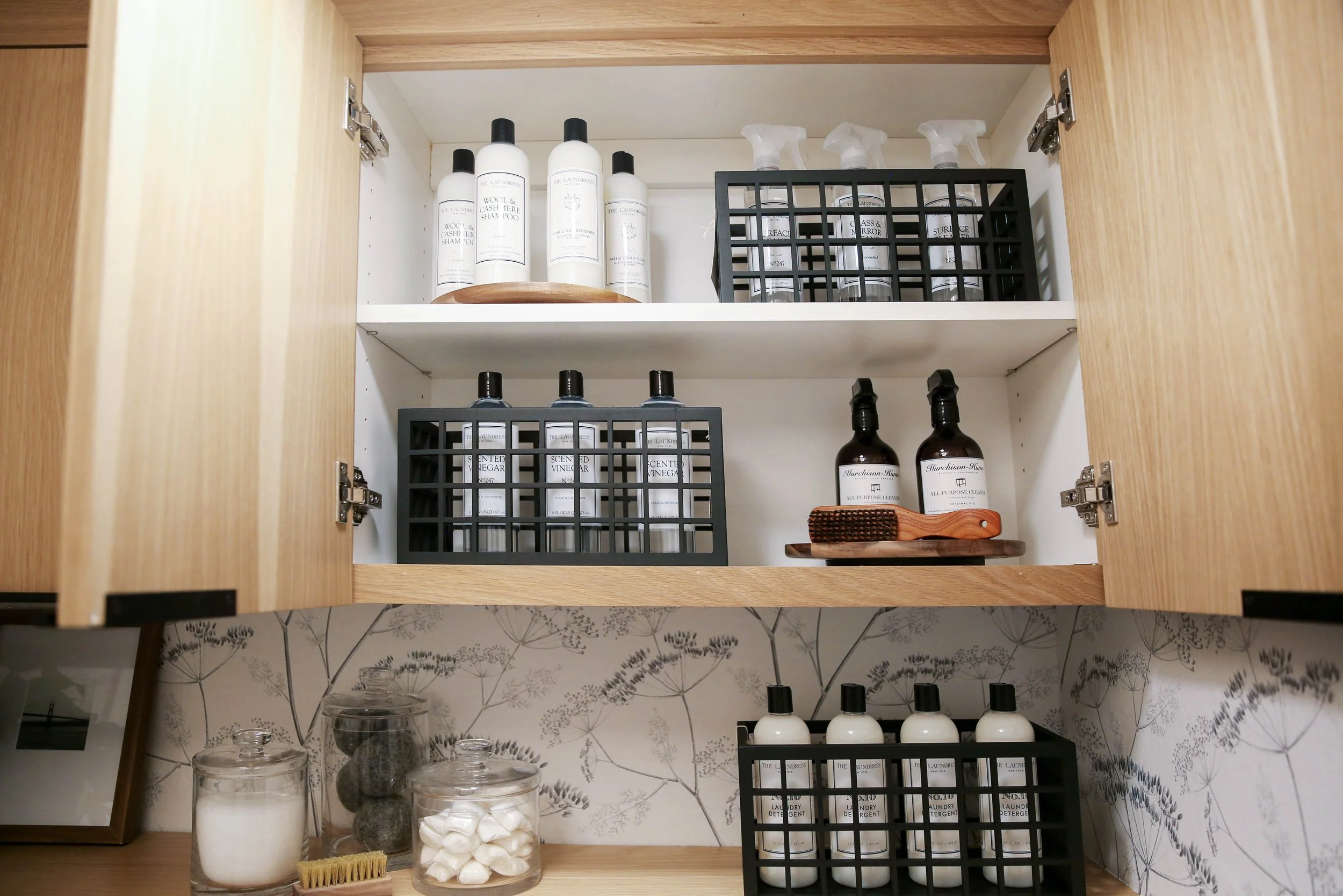 Laundry room cabinet organized with cleaning products, sprays and home-care essentials ready for daily use.