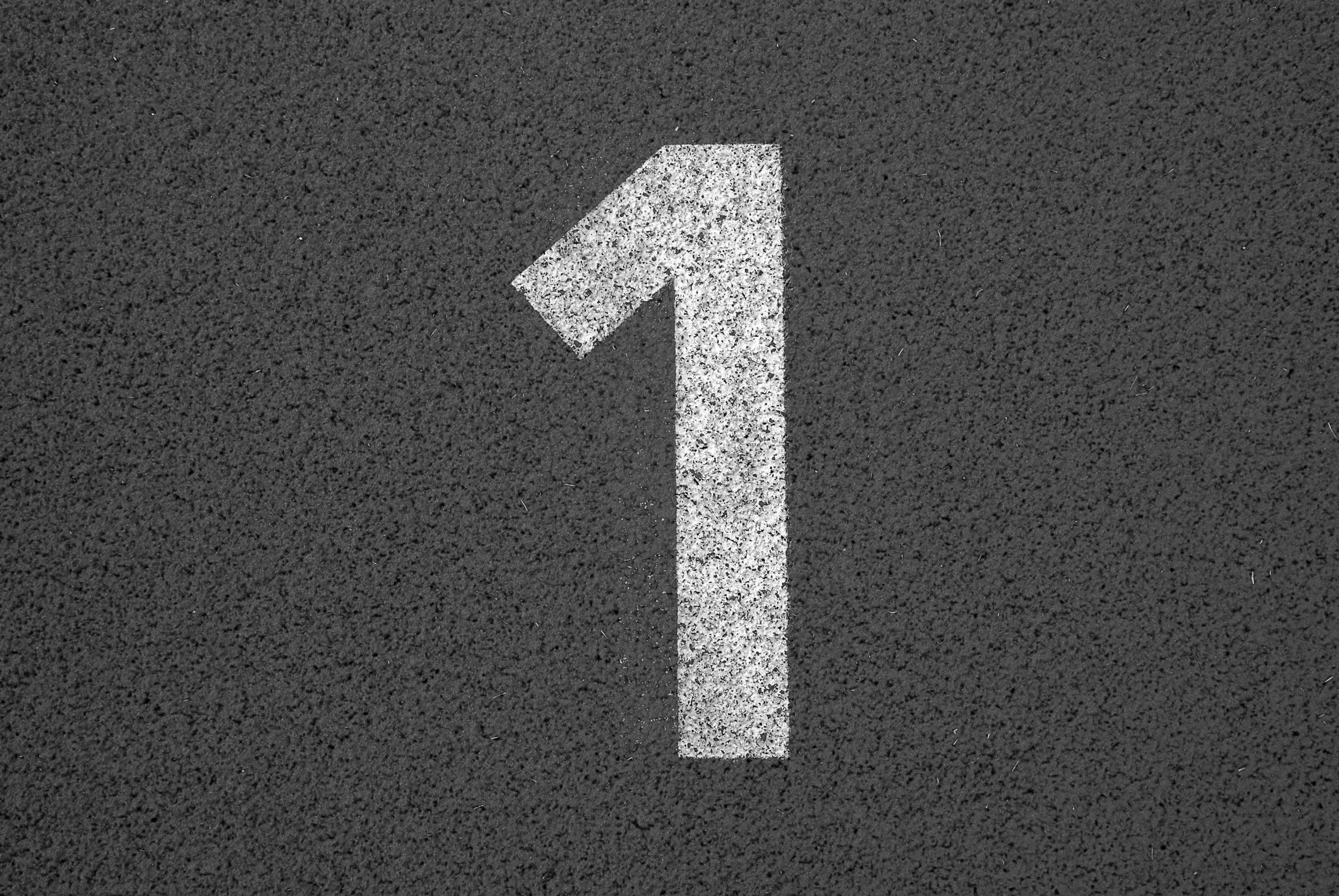 A white painted number 1 on a dark commercial surface