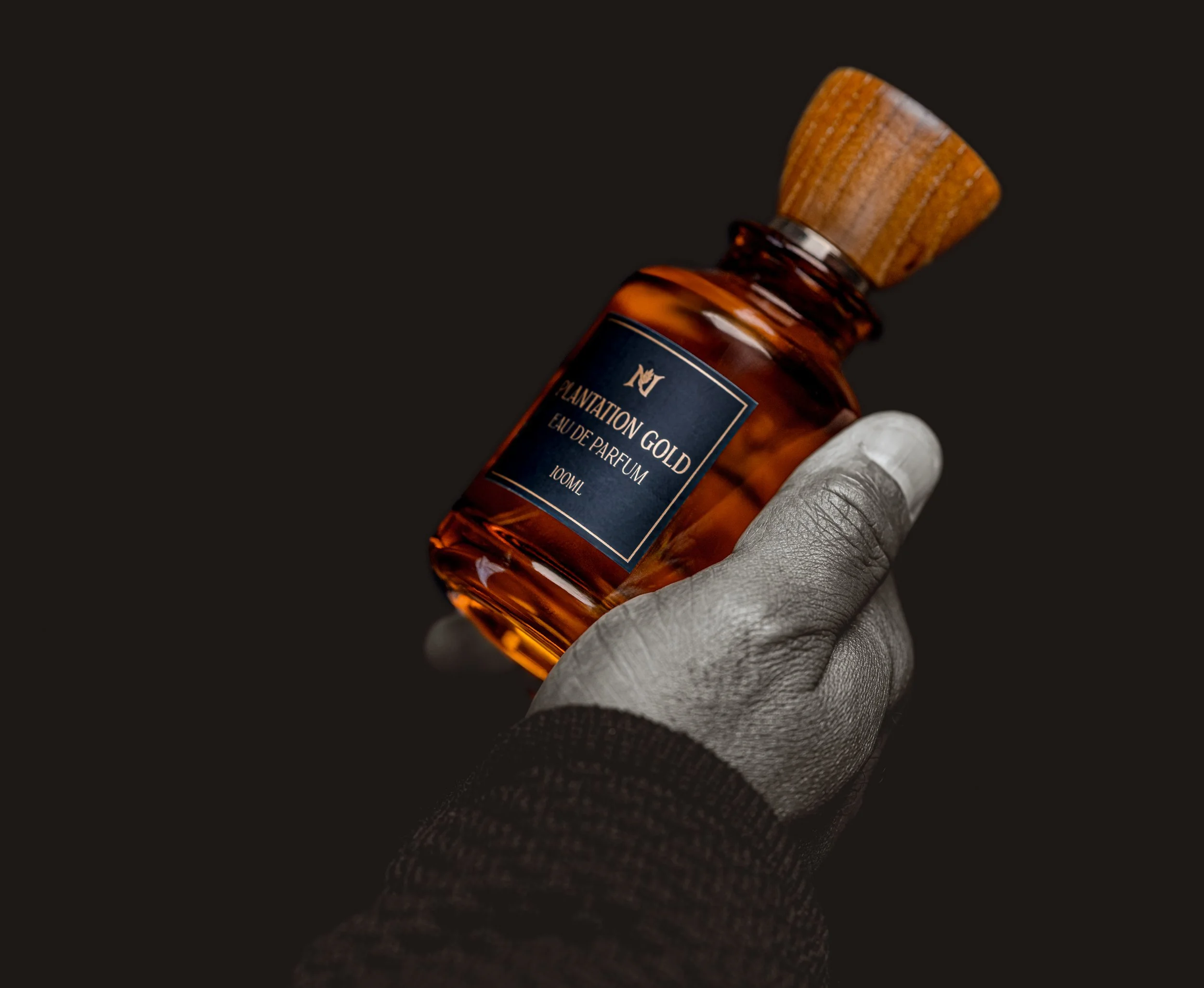 A hand of holding a bottle of premium luxury fragrance.