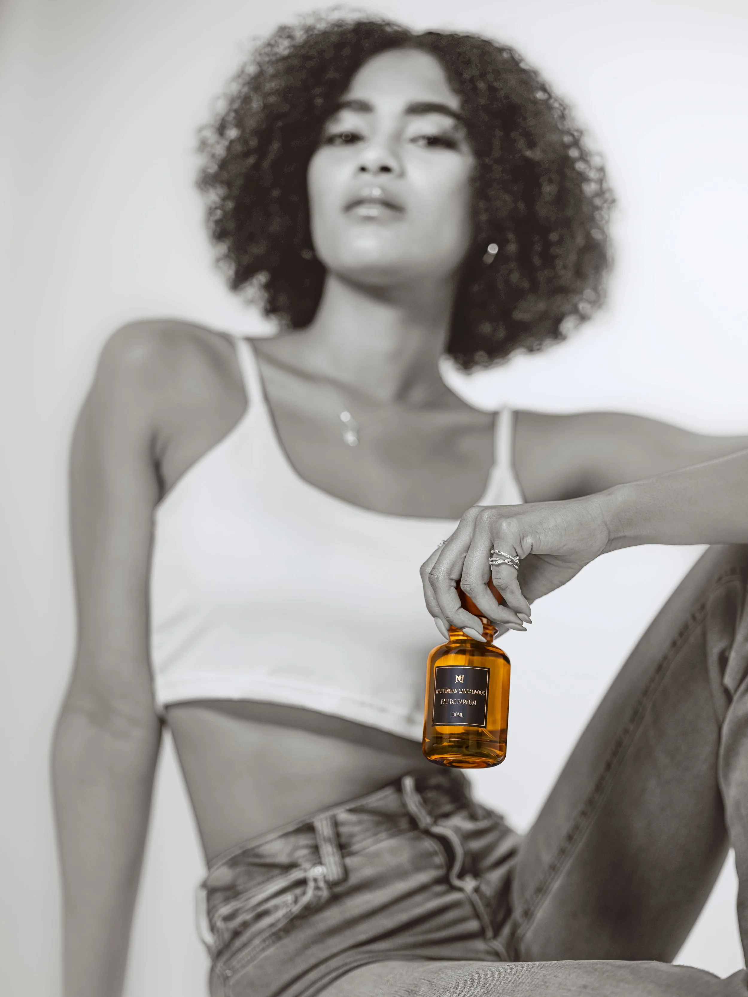  An advertisement featuring a model holding a premium bottle of perfume.